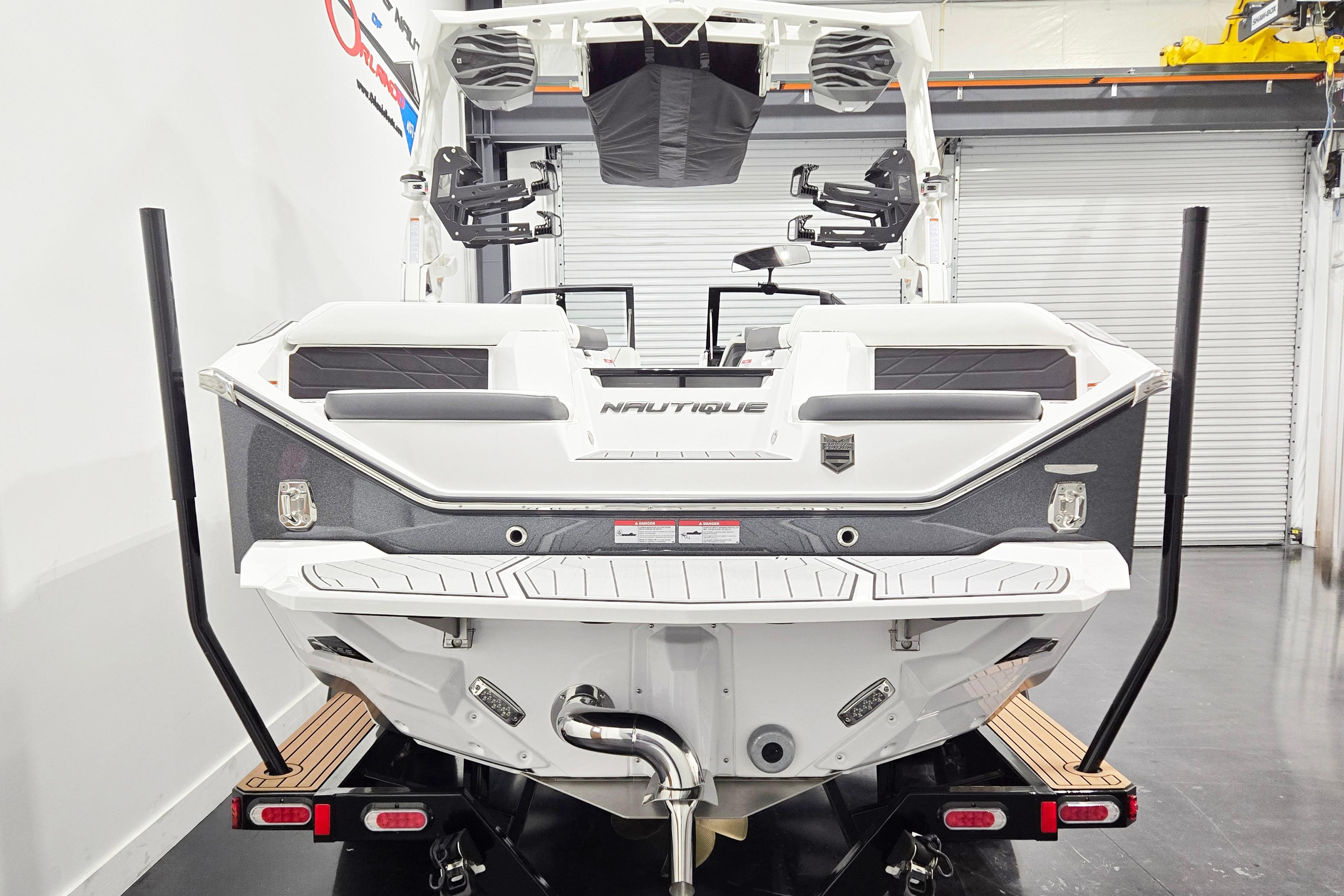 2026 Nautique Super Air Nautique S23 boat rear view in showroom setting.