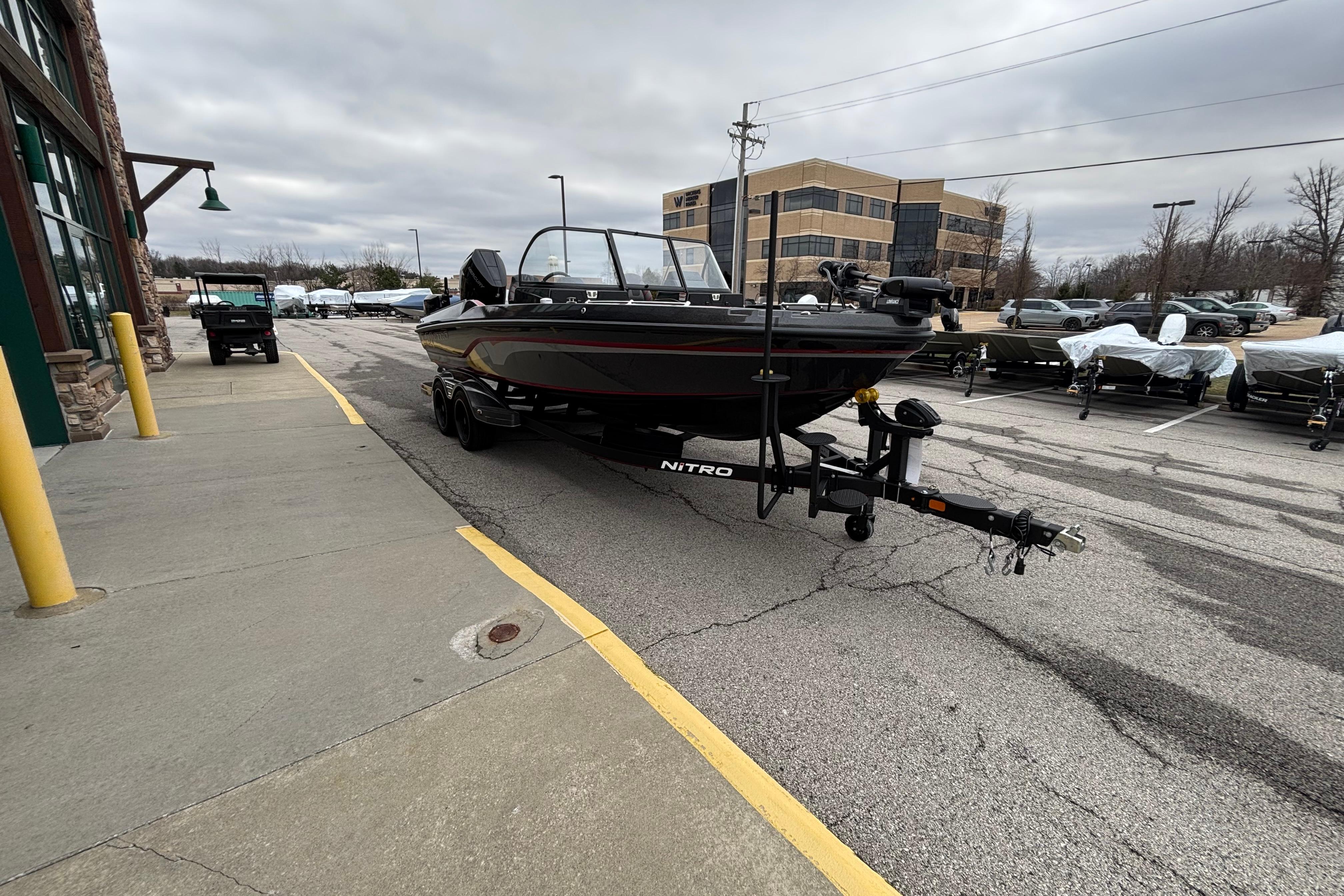 2024 Nitro ZV21 Pro boat on trailer in parking lot, overcast sky.