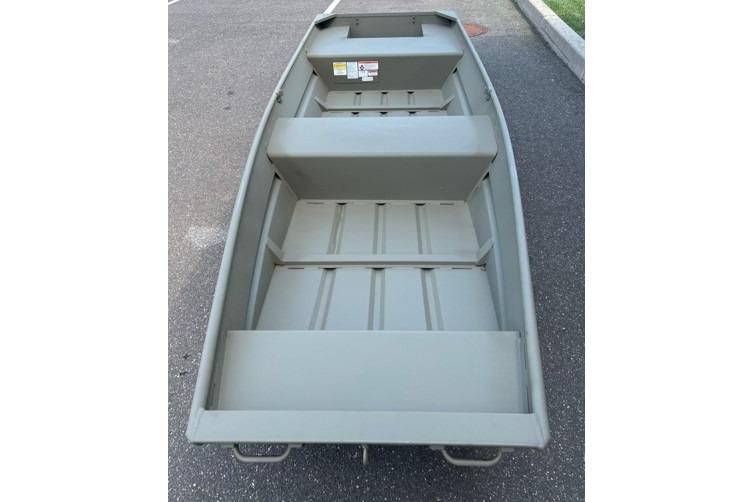 2026 Tracker Grizzly 14 Jon boat on pavement, showcasing interior seating and storage.