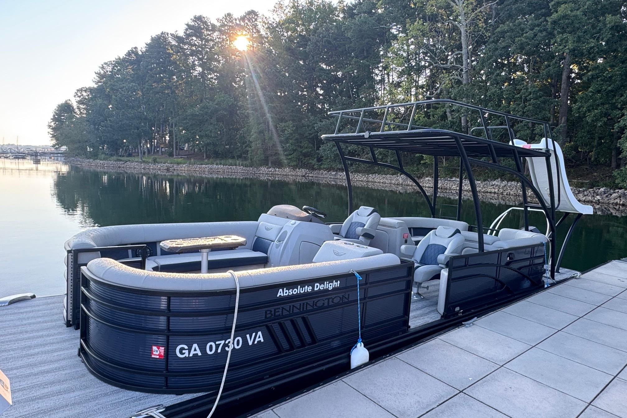 2025 Bennington 26 L Top Deck pontoon boat docked by a serene lake.