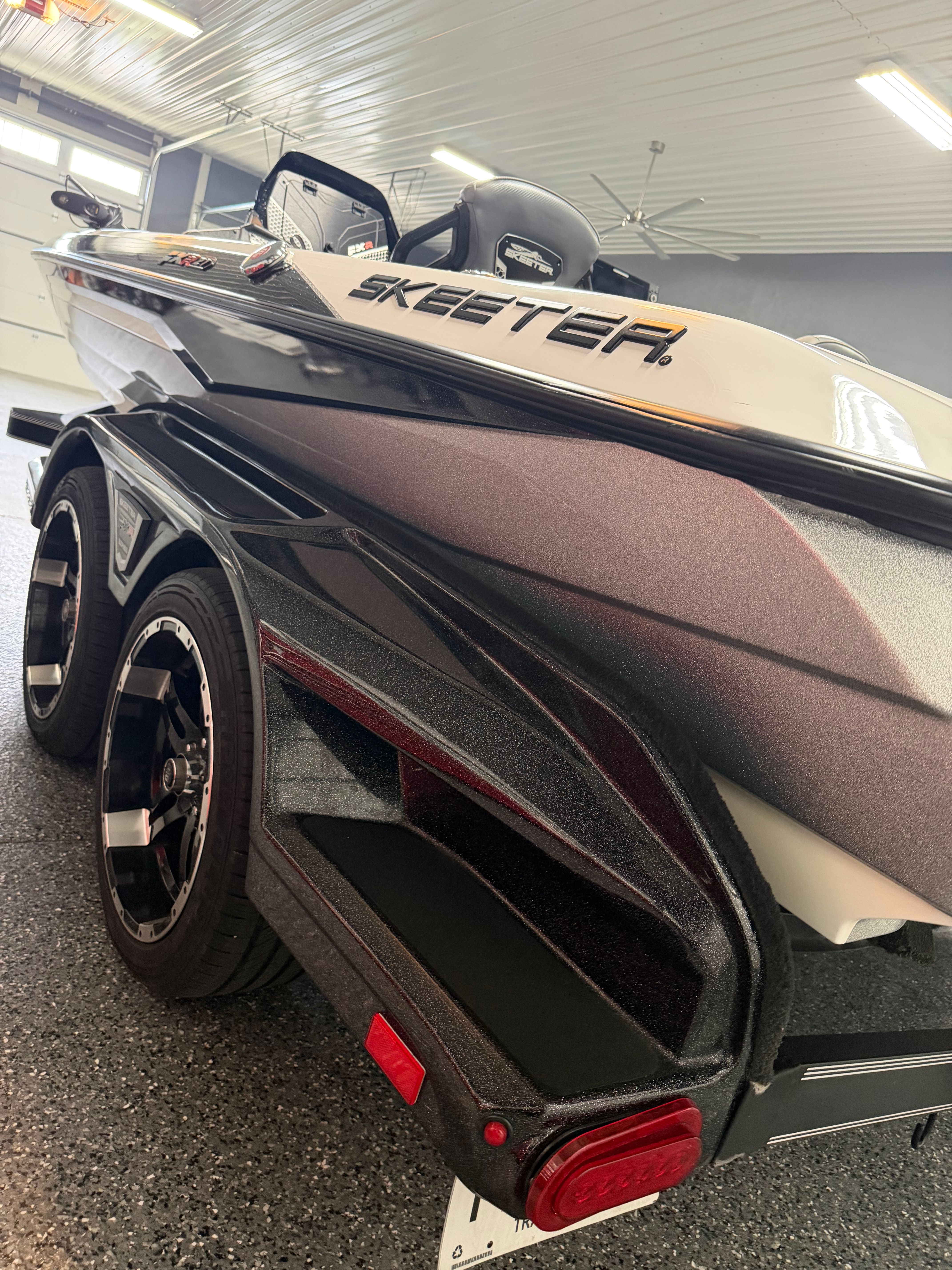 A Skeeter FXR21 Limited boat on a trailer in a garage.
