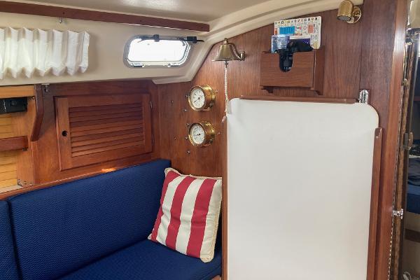 Interior of 1989 Catalina 30 sailboat with blue seating and nautical decor.
