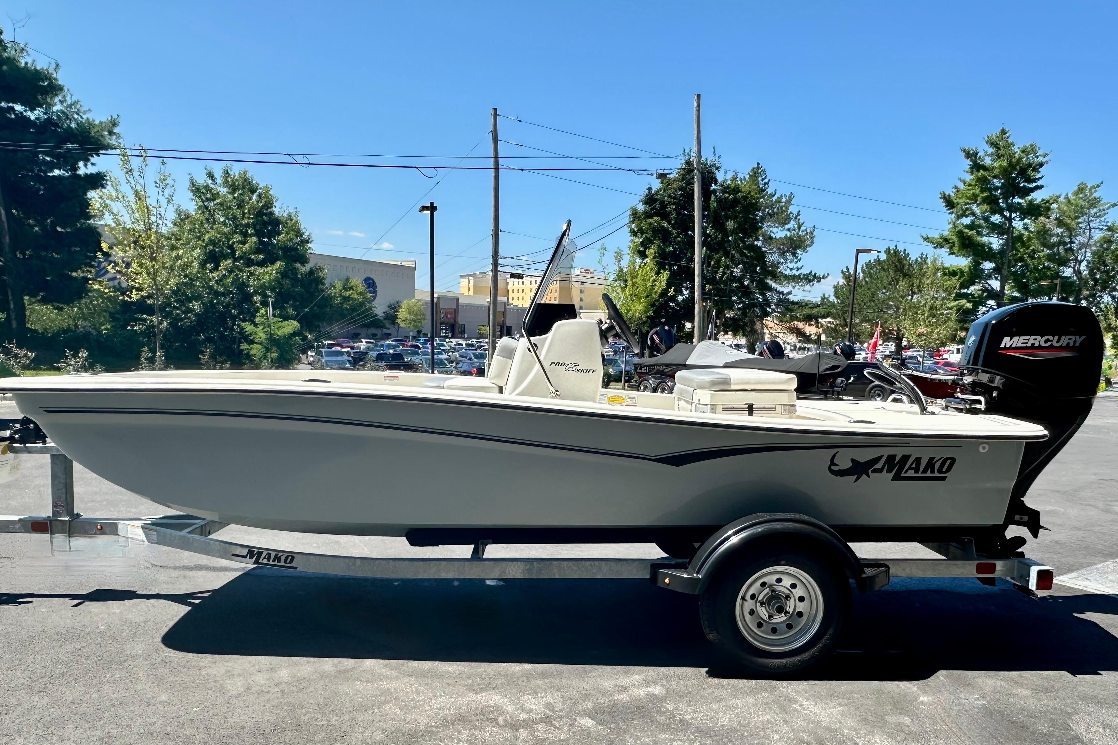 2026 Mako Pro Skiff 15 CC boat on trailer, outdoors, with Mercury engine.