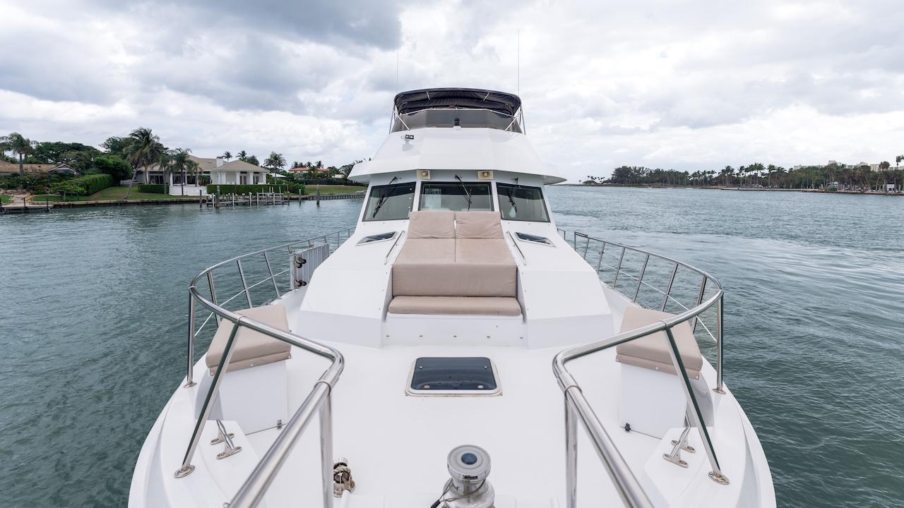 1998 Hatteras 74 Sport Deck Motor Yacht on calm water, featuring spacious deck and seating.