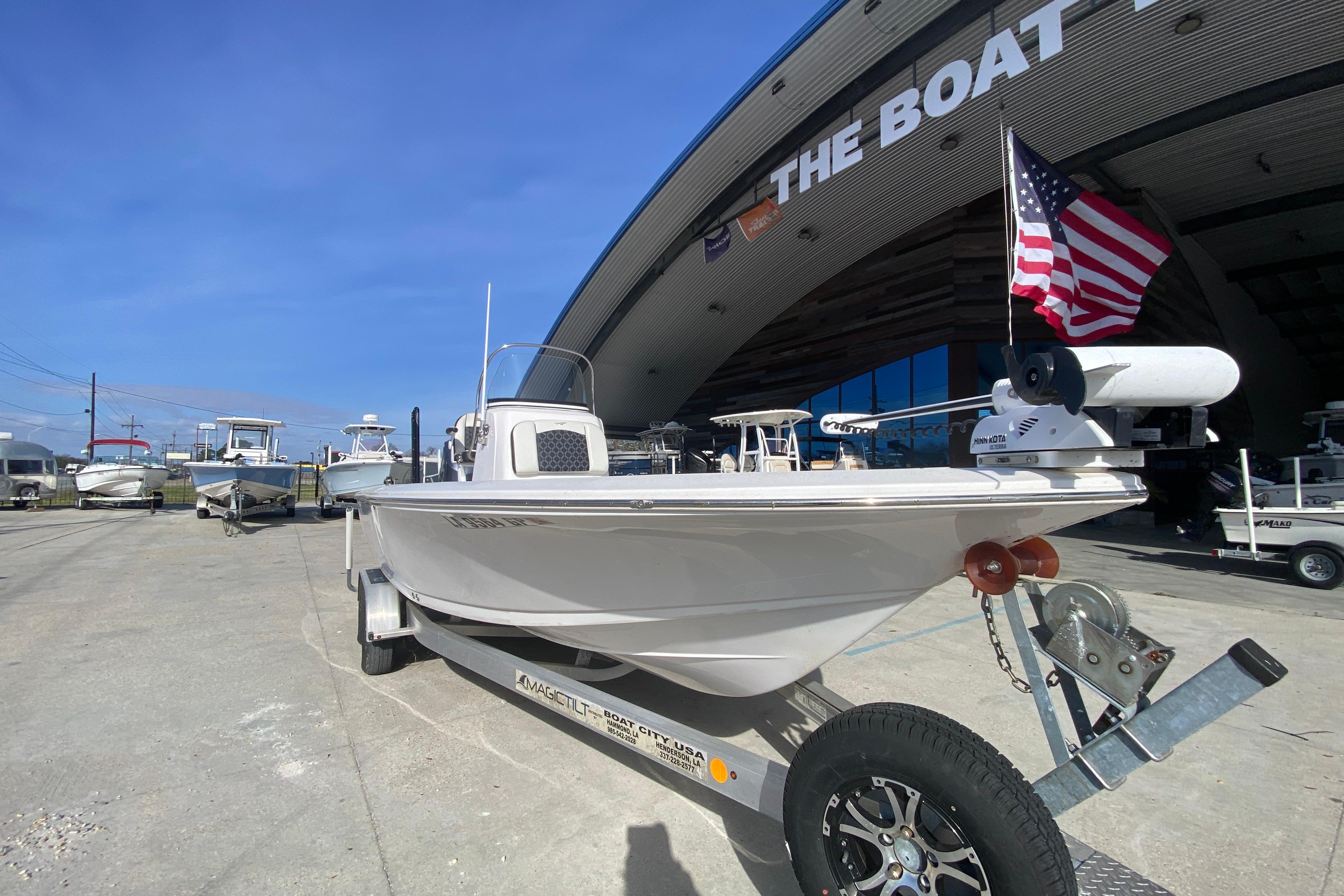 2023 Tidewater 2410 Bay Max boat on trailer, displayed outdoors with American flag.