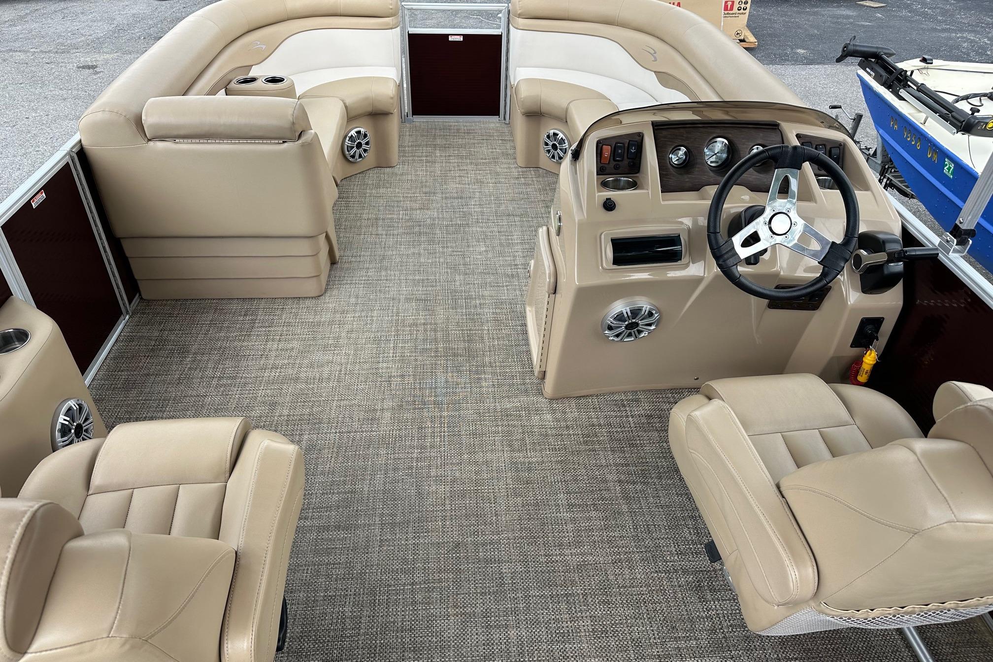 2016 Bennington 24 SCWX pontoon boat interior with beige seating and steering console.