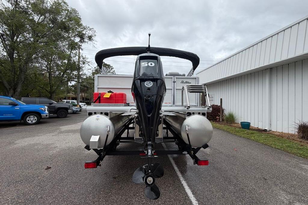 2026 Sun Tracker Party Barge 16 DLX pontoon boat with outboard motor, parked outdoors.