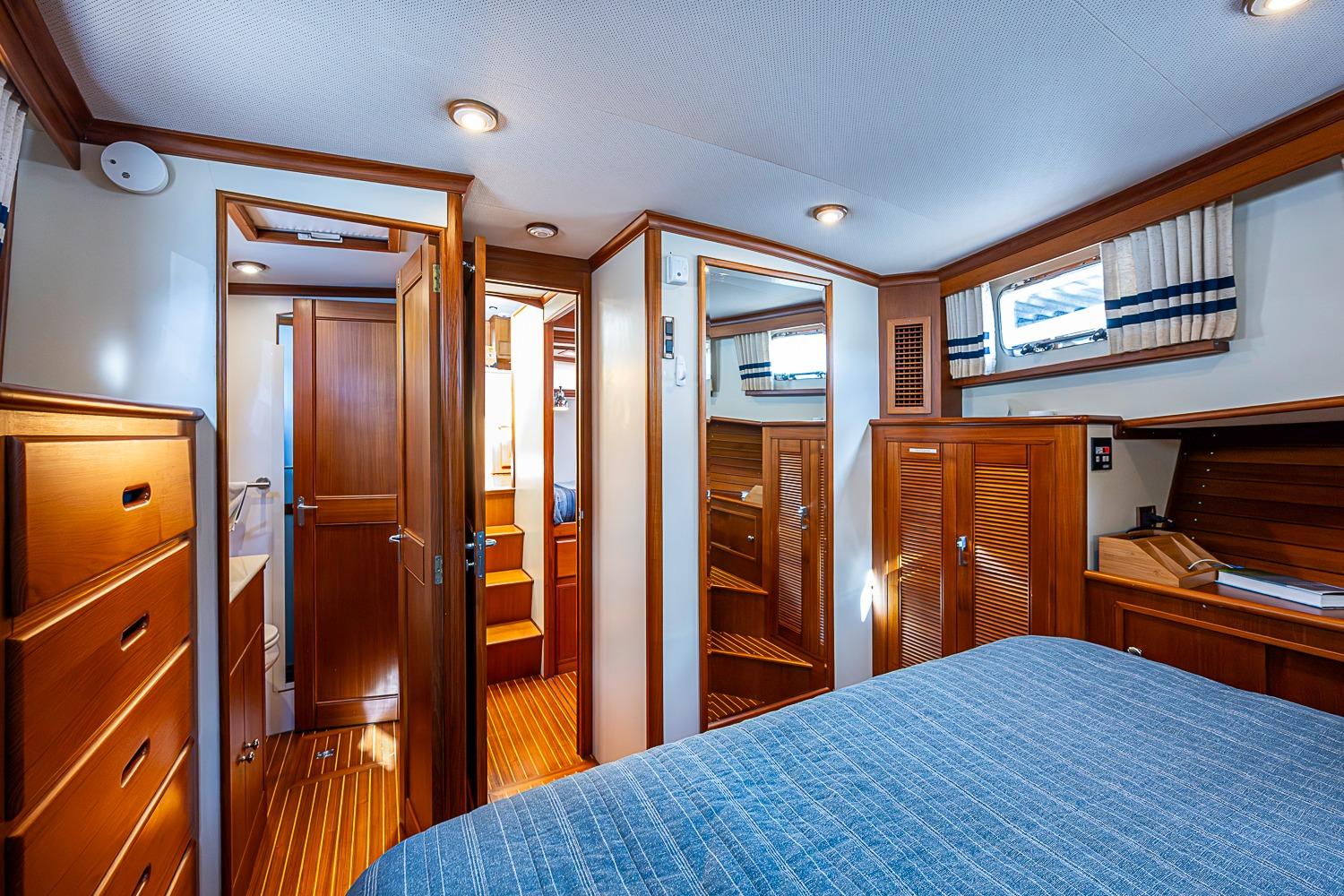 Luxurious cabin interior of 2002 Grand Banks 42 Europa yacht with wooden furnishings.