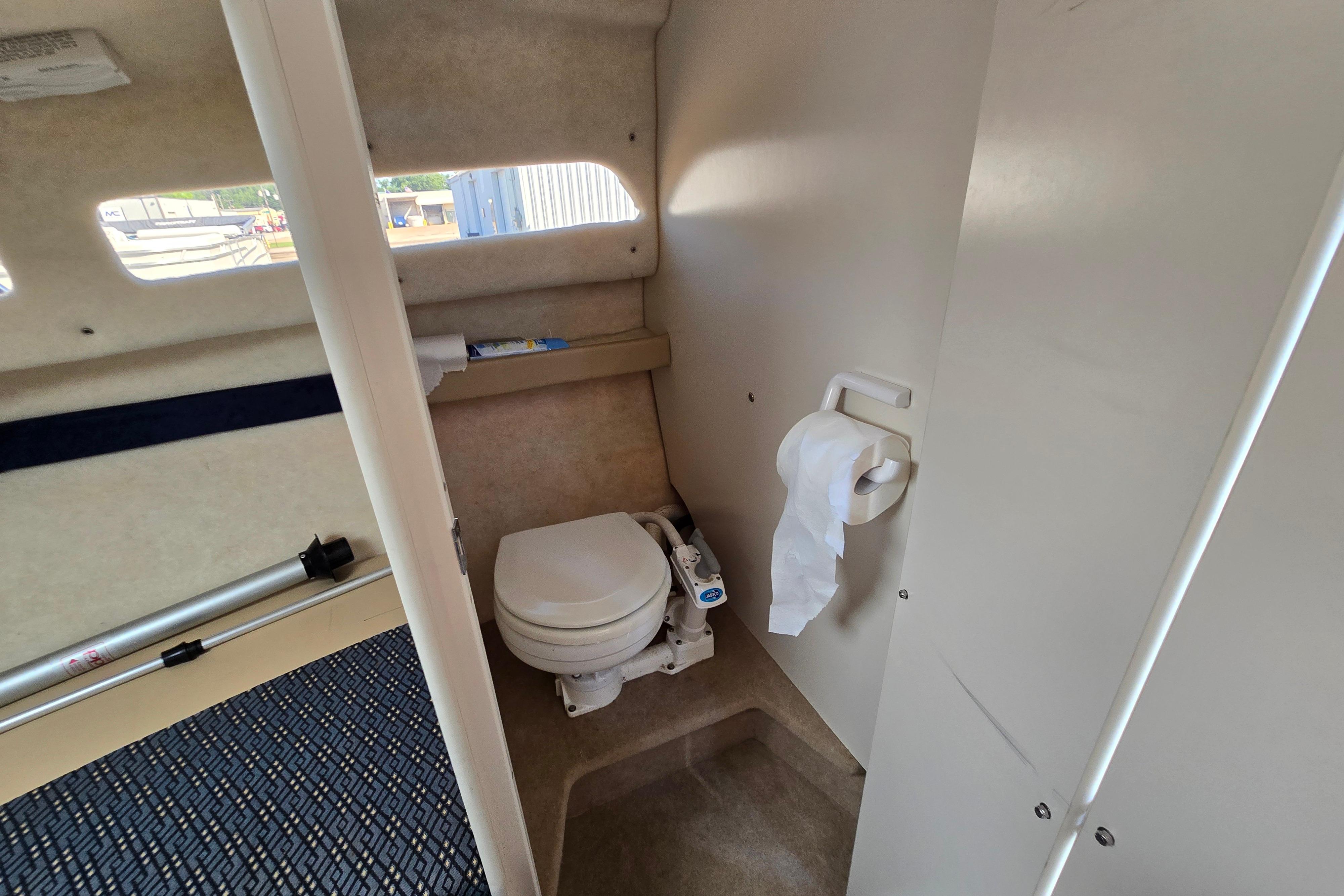 2006 Bayliner 222 Classic boat interior with compact toilet and window view.