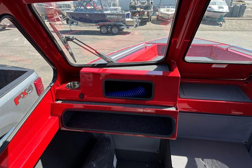Interior view of 2026 Weldcraft 240 Maverick DV boat, featuring red dashboard and windshield.