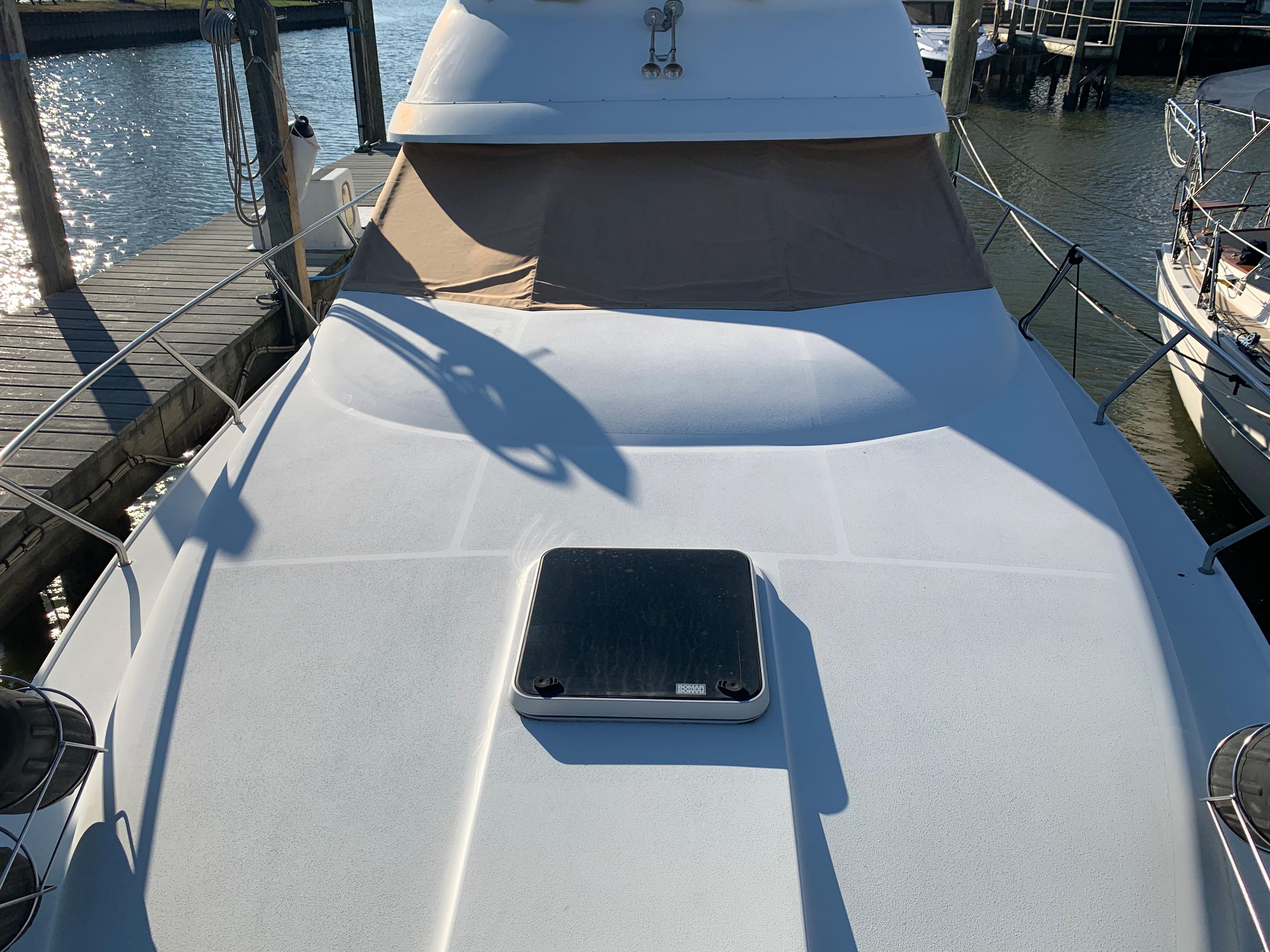 1992 Silverton 34 Aft Cabin Motor Yacht docked, showcasing spacious deck and hatch.