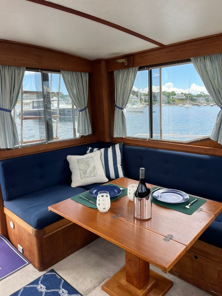 Interior of a 1988 Cape Dory 33 Flybridge with a cozy seating area and table.