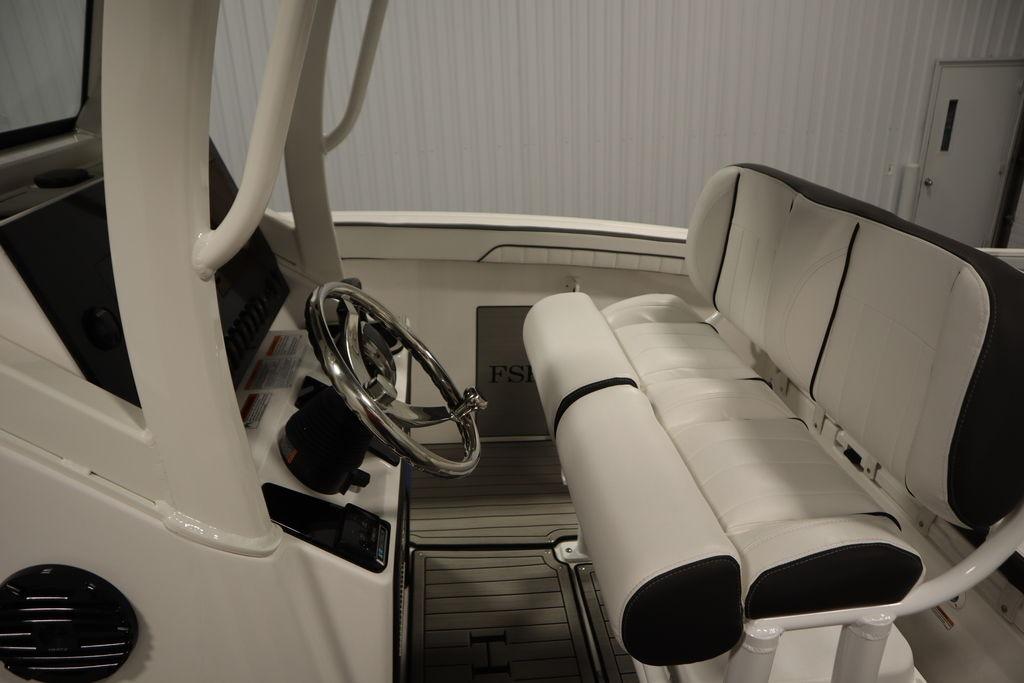 2026 Yamaha Boats 255 FSH Sport E interior with steering wheel and seating.
