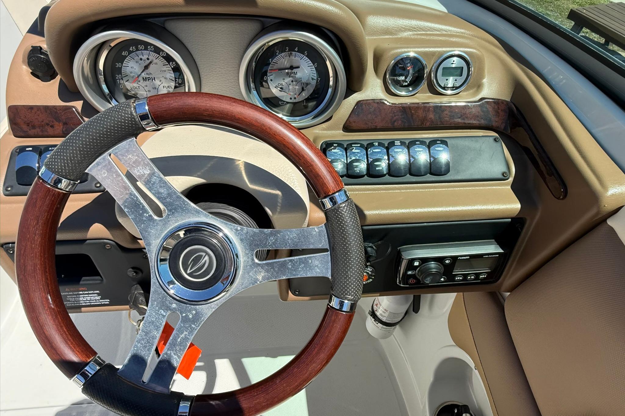 Steering wheel and dashboard of 2016 Crownline 255 SS boat, featuring gauges and controls.