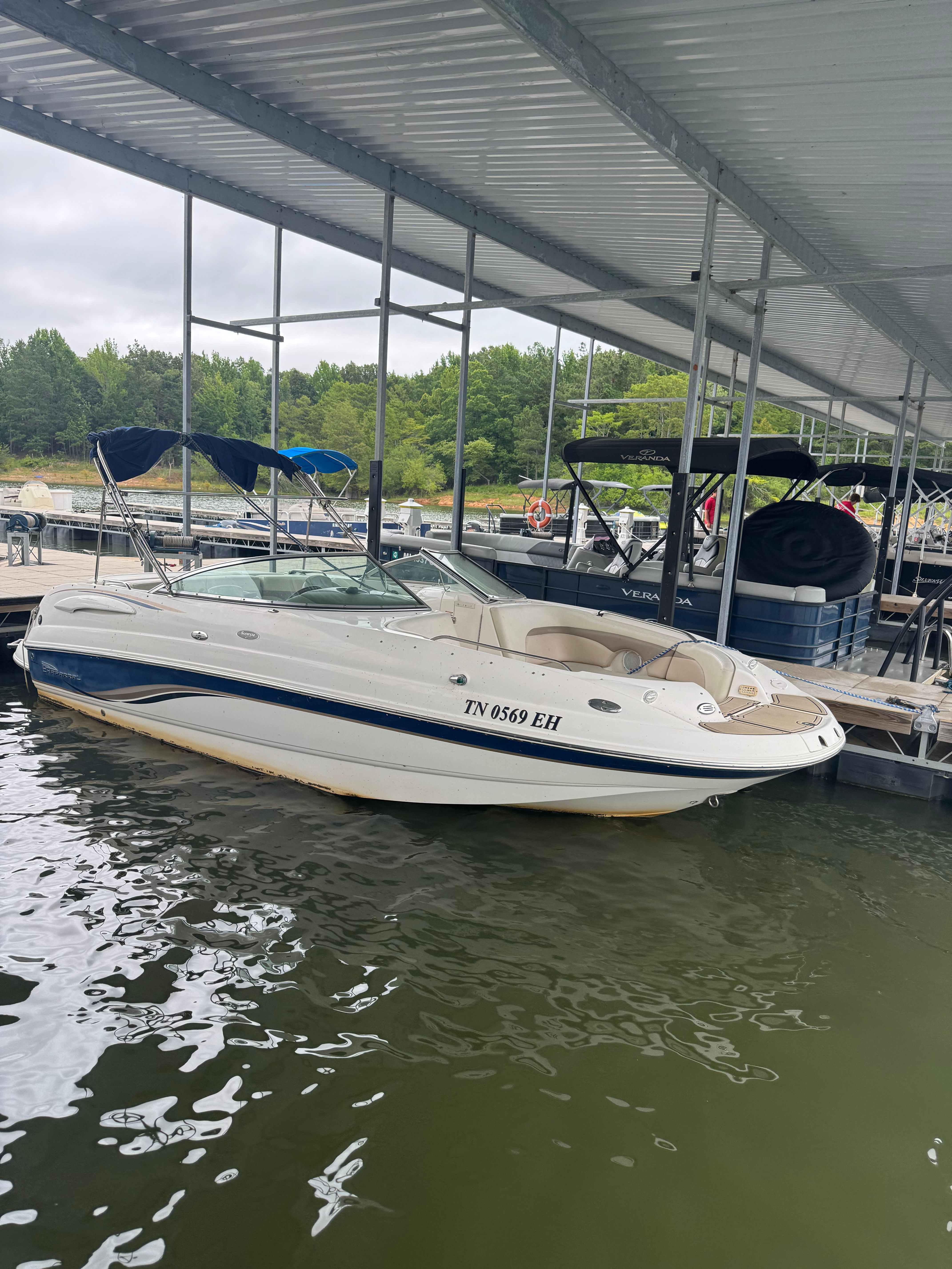 A white Chaparral Sunesta 223 boat docked on the water.