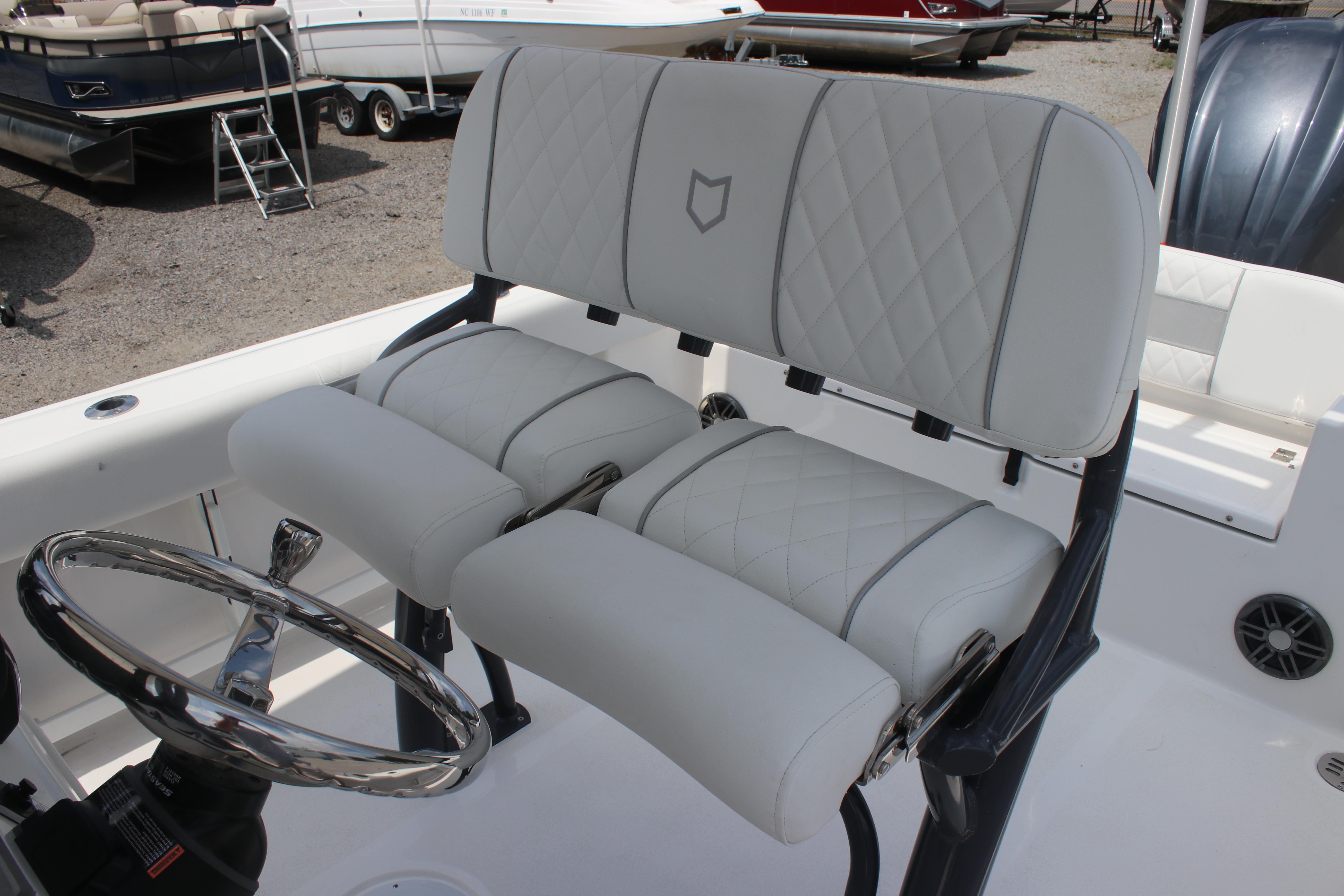 2026 Sea Fox 248 Commander boat interior with white cushioned seating and steering wheel.