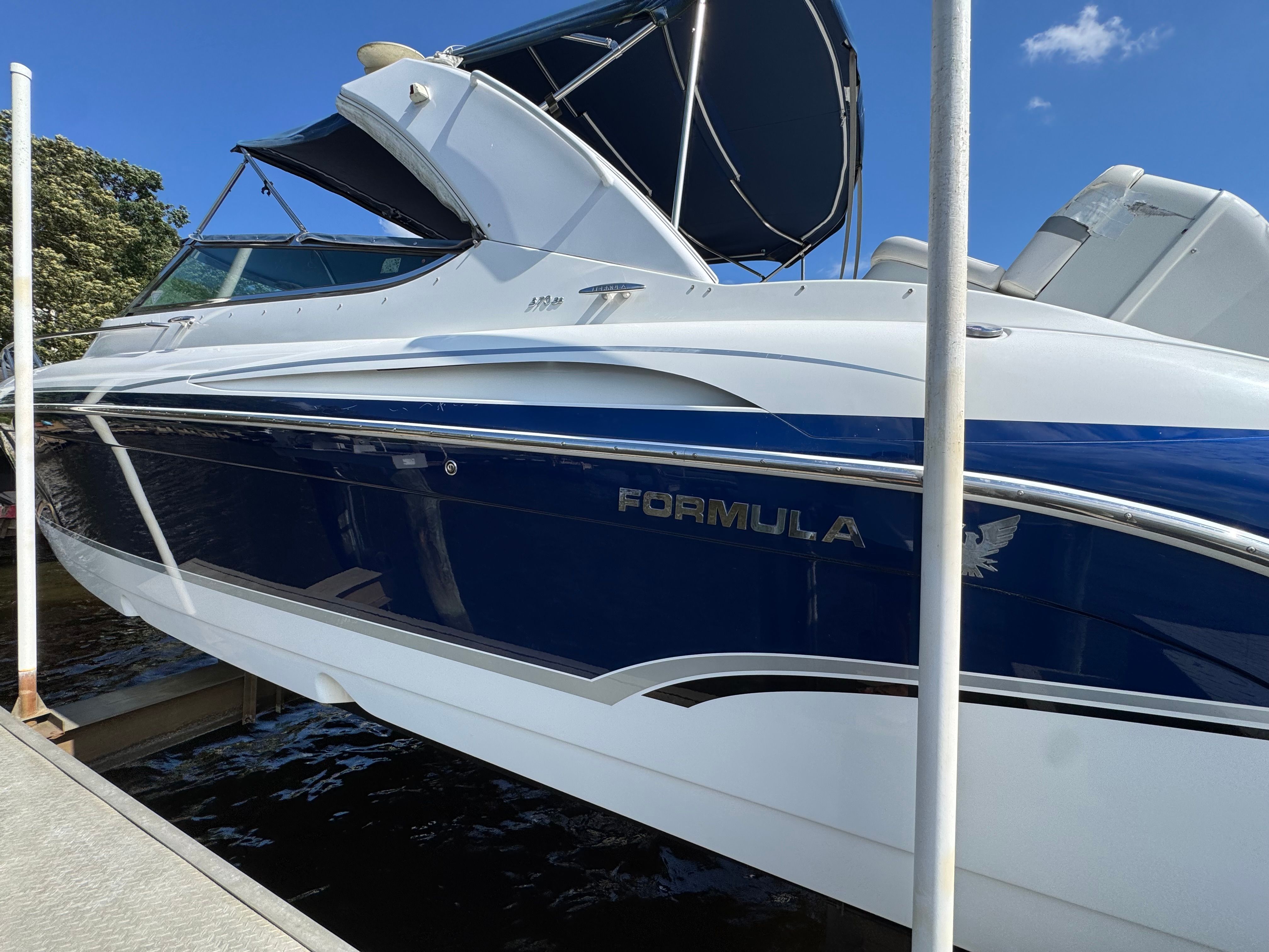 A blue and white boat with an open canopy docked at the pier.