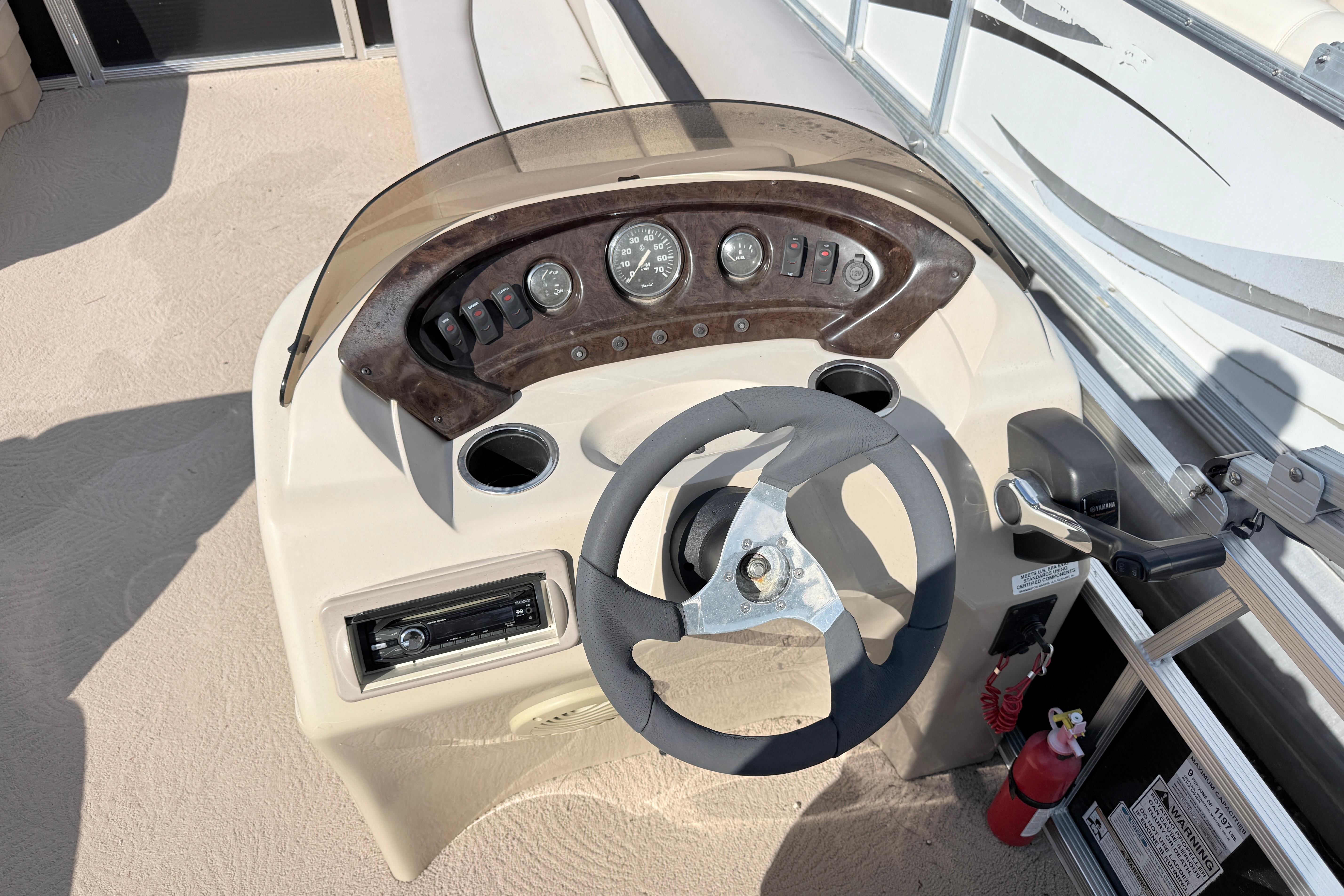 Steering console of a 2010 Bennington 20SLi pontoon boat with gauges and controls.
