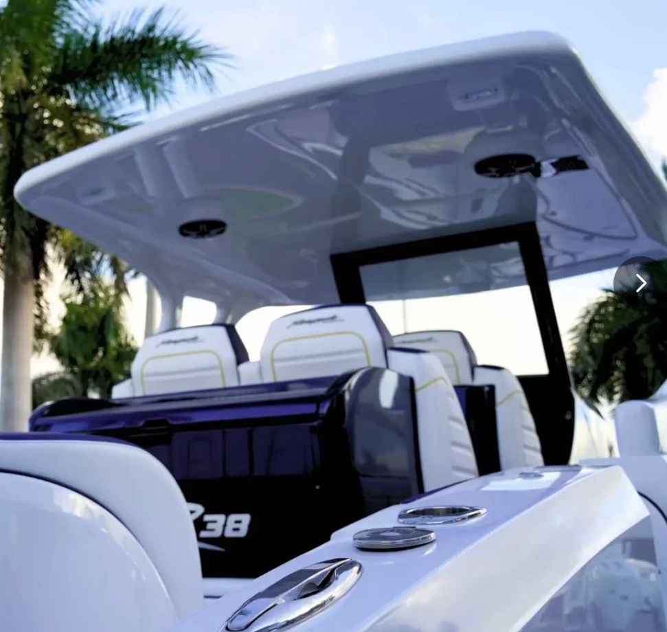 The image shows the cockpit of a modern boat with white seats and a large canopy.