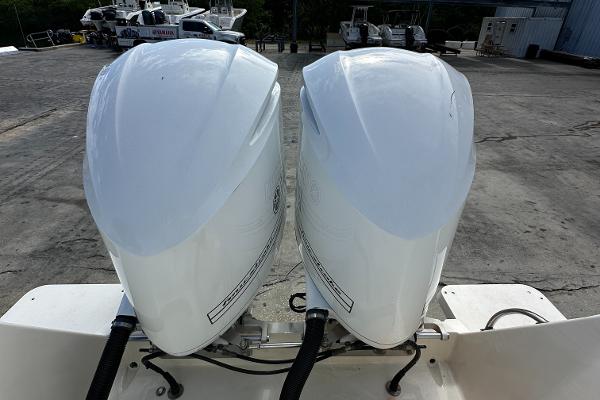 Twin outboard motors on a 2005 Intrepid 323 boat, parked on concrete.
