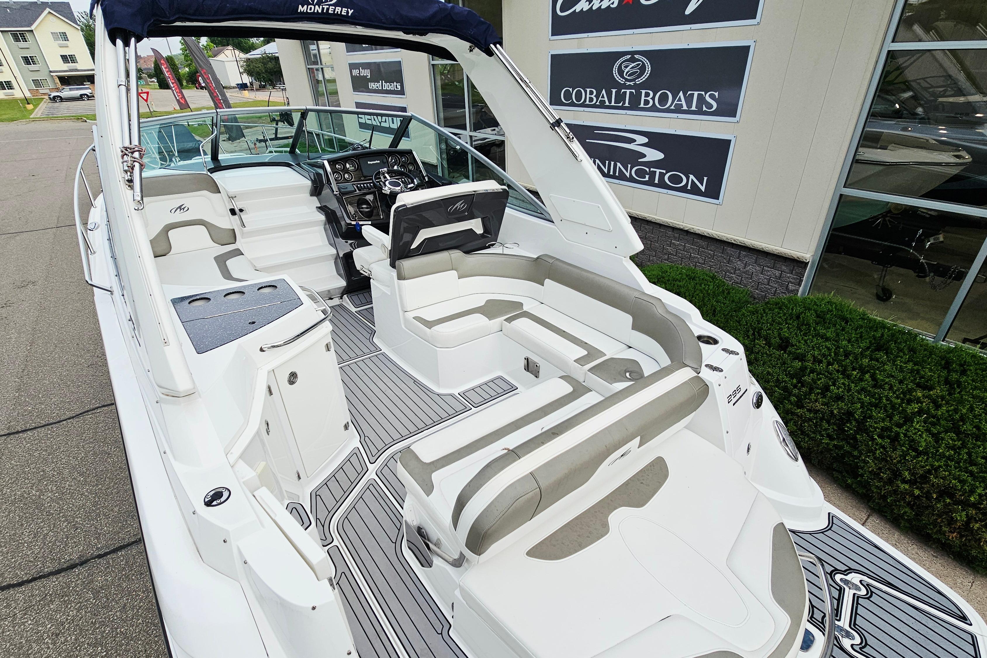 2016 Monterey 295 Sport Yacht with spacious seating and modern dashboard, docked near dealership.