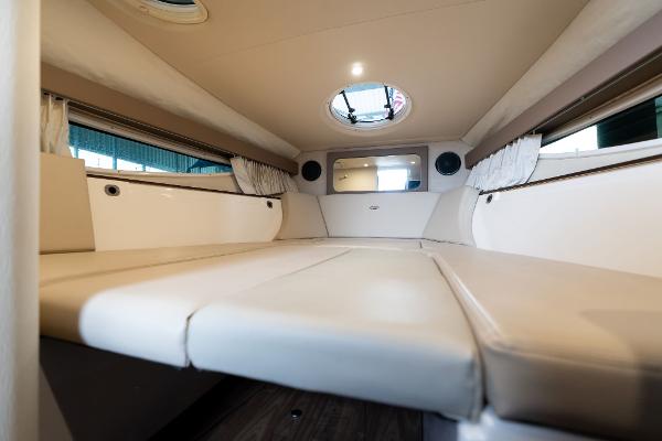Interior cabin of a 2016 Regal 28 Express boat, featuring comfortable seating and porthole.