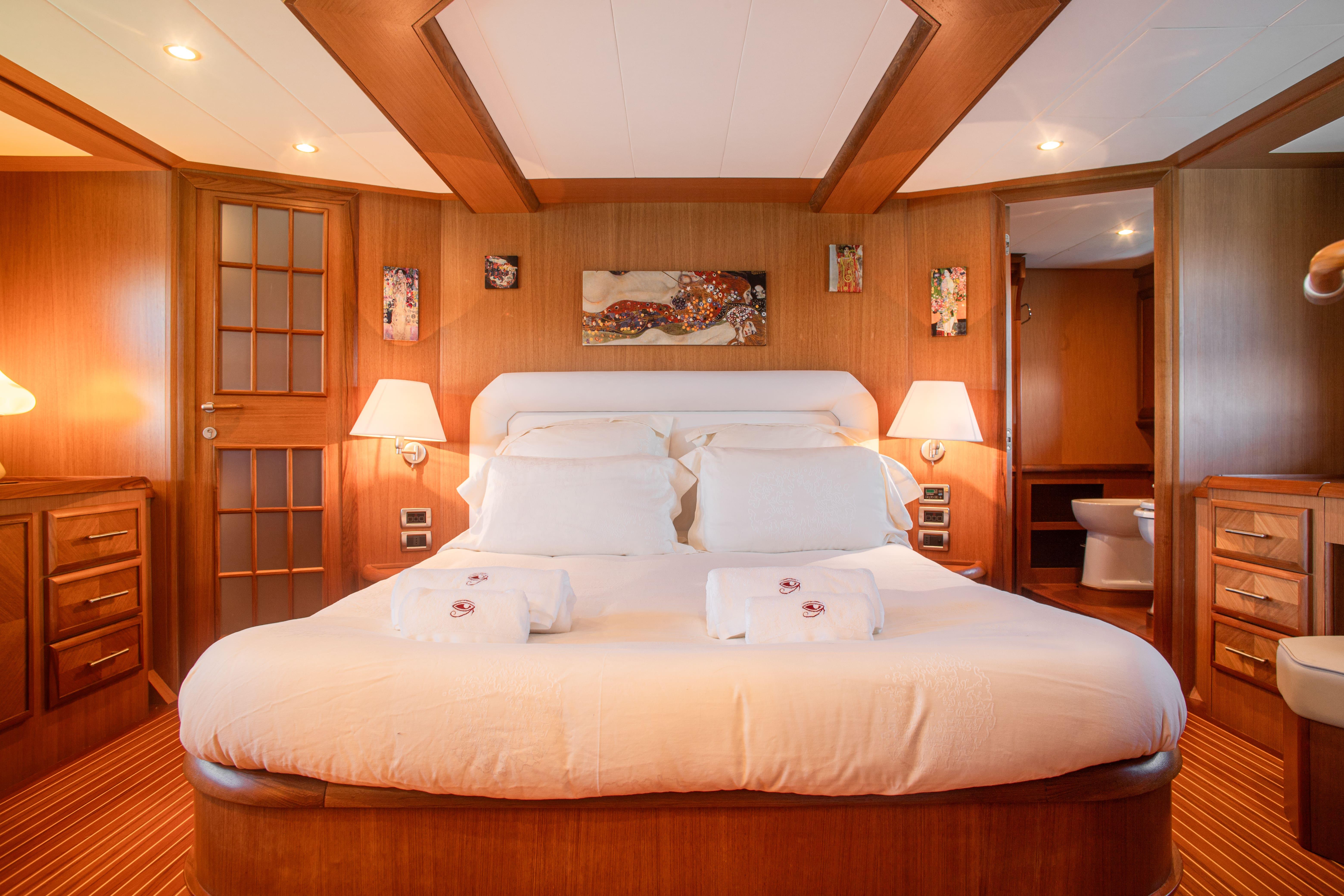 Luxurious bedroom interior of 2005 Mochi Craft 74' Dolphin yacht with elegant wood finishes.
