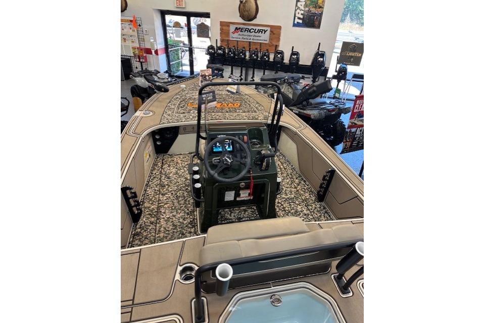 2025 Mako 18 Pro Skiff Backwater Edition boat interior with steering console in showroom.
