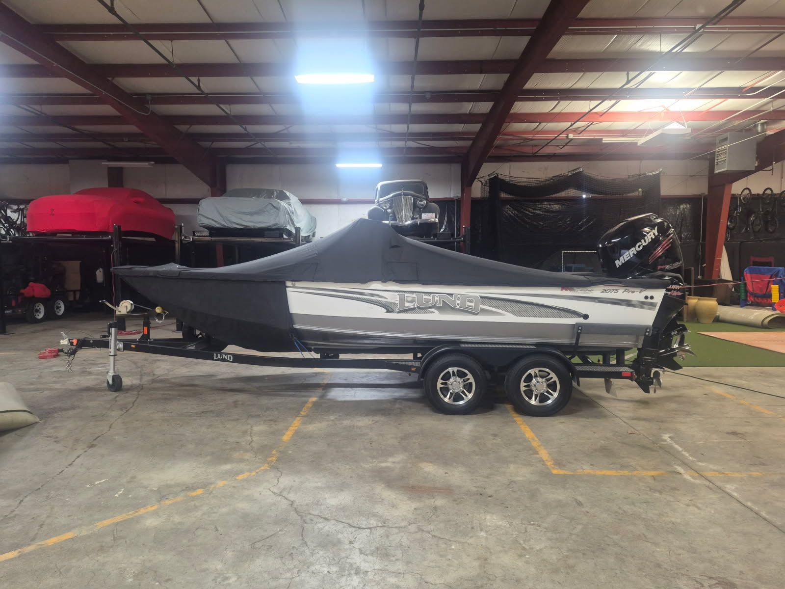 A 2017 Lund Pro-V 2075 boat on a trailer inside a warehouse.