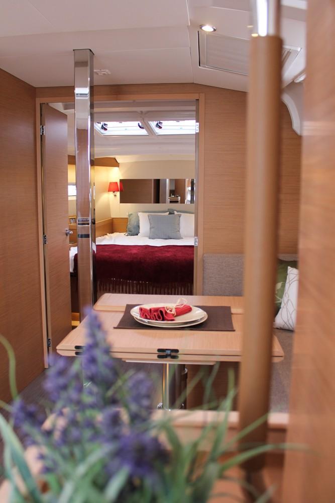 2025 Jeanneau Sun Odyssey 440 interior with elegant wood finish and cozy bedroom view.
