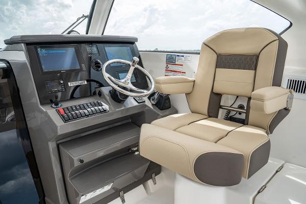 Manufacturer Provided Image: Captain's chair and helm of a 2019 Pursuit OS 355 Offshore boat.