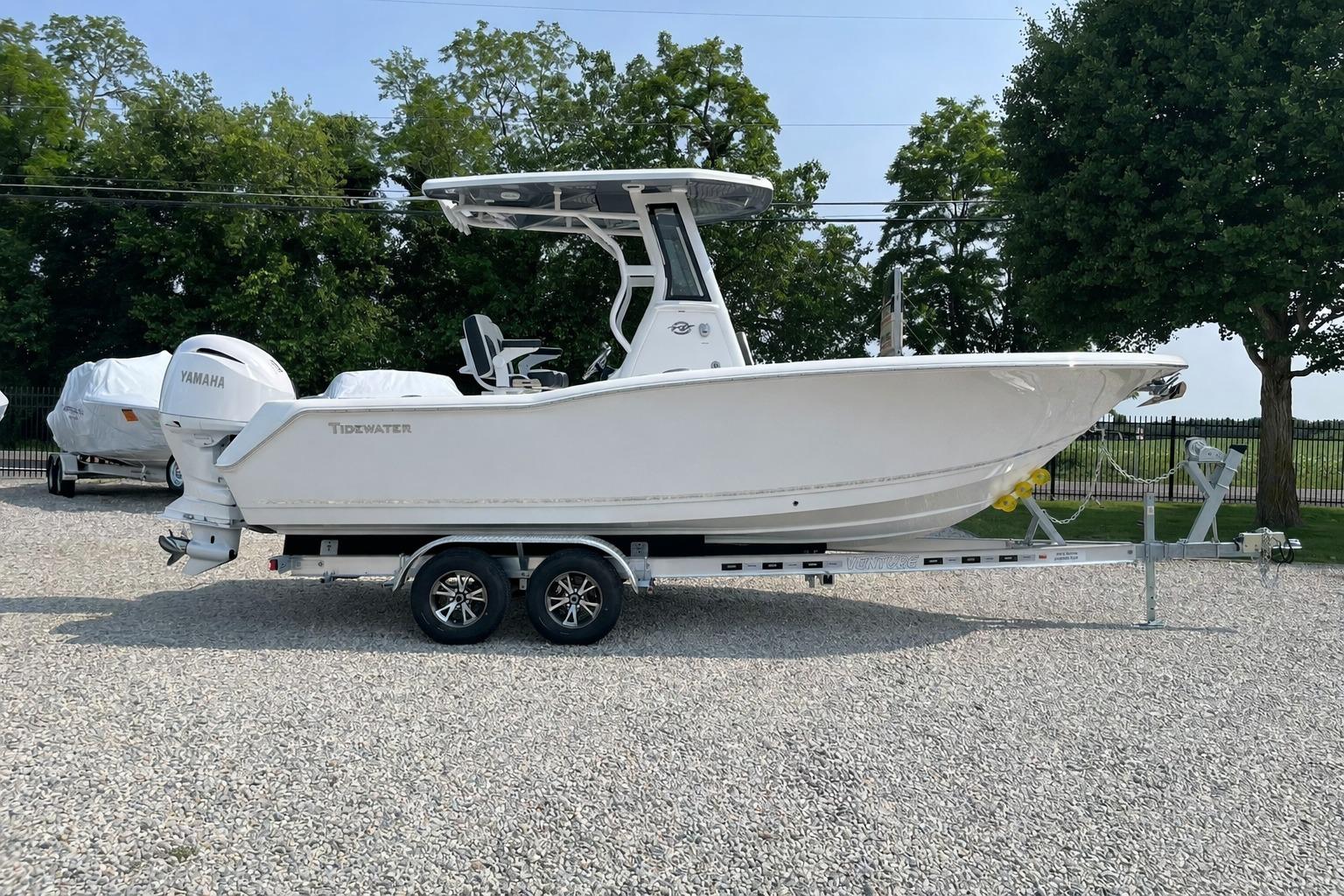 2026 Tidewater 232 CC Adventure boat on trailer, parked outdoors.