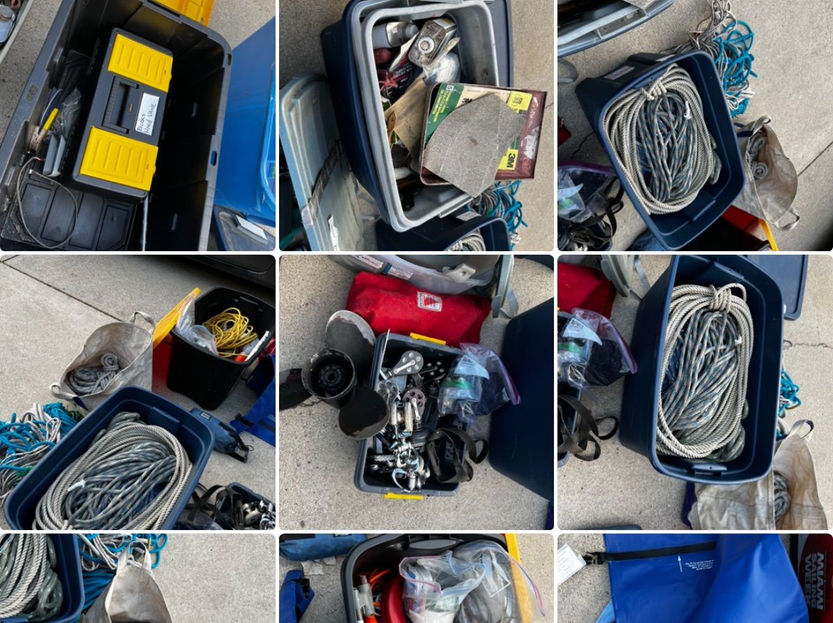 Various boating equipment and accessories in containers spread out on the ground.