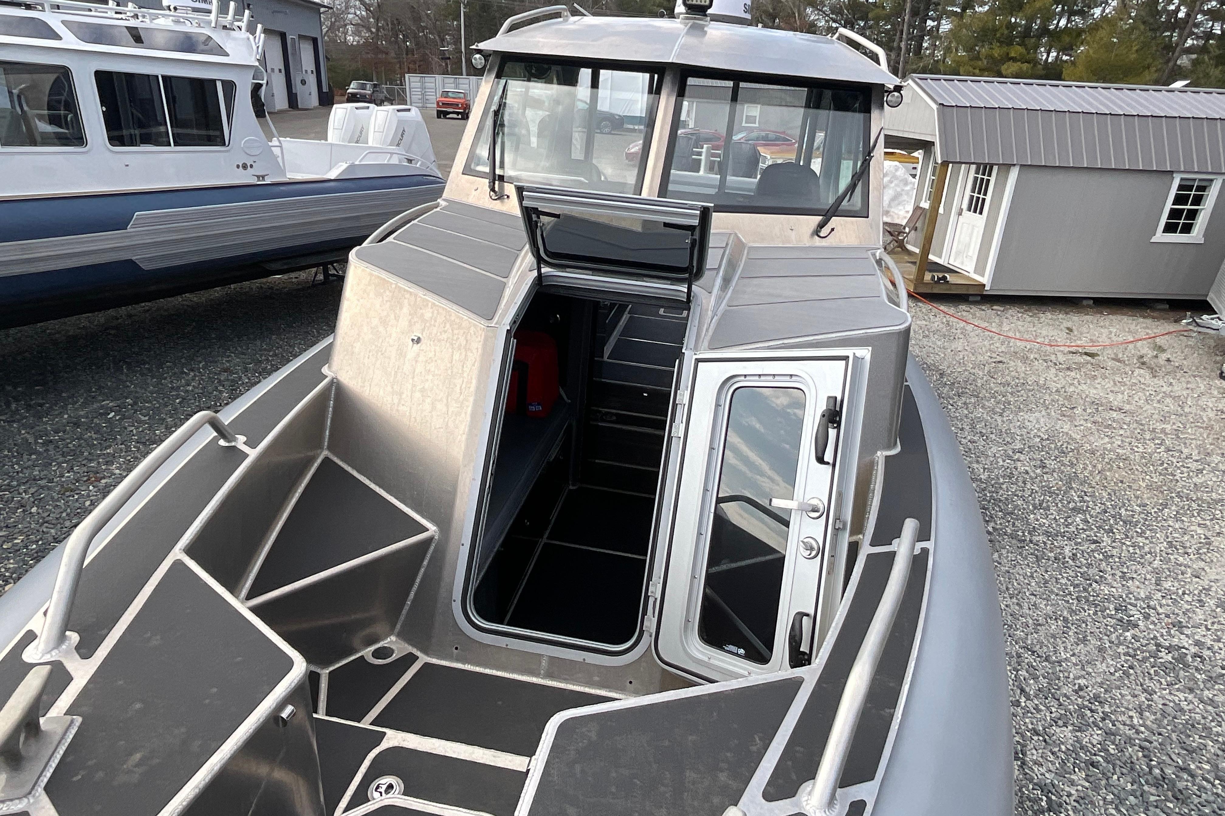2025 Life Proof 31 GT Coupe boat with open cabin door, docked outdoors.