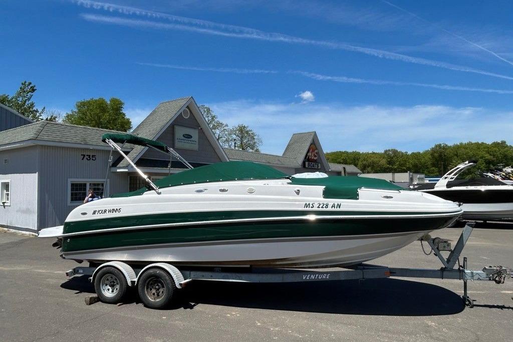 2006 Four Winns 244 Funship boat on trailer, parked outside dealership under clear blue sky.