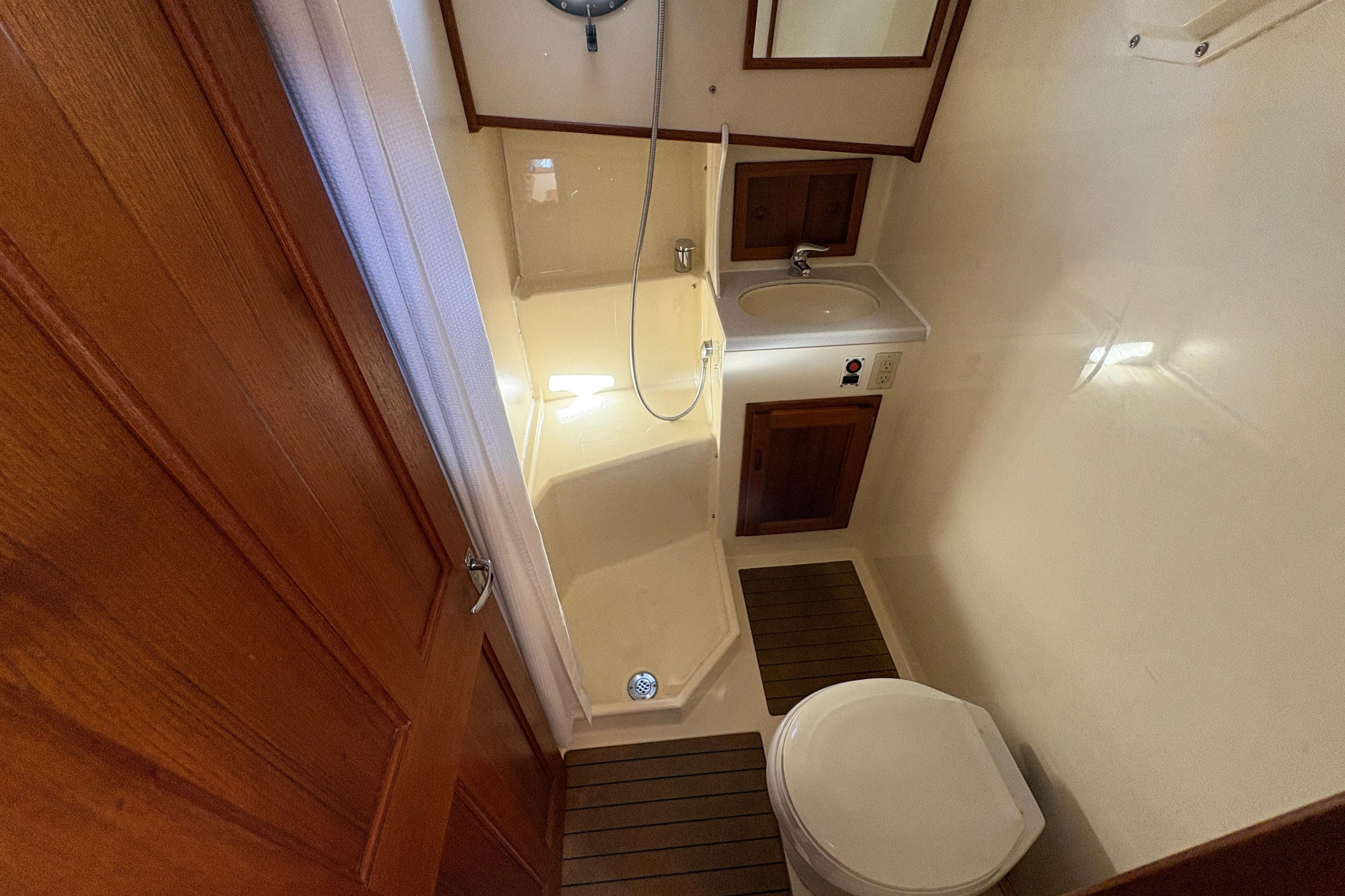 Bathroom interior of a 2004 Nordic Tug 32, featuring shower, sink, and toilet.