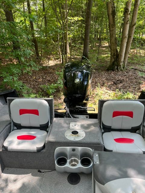 The image shows the rear of a 2016 Tracker Pro Guide V-175 Combo boat in a wooded area.