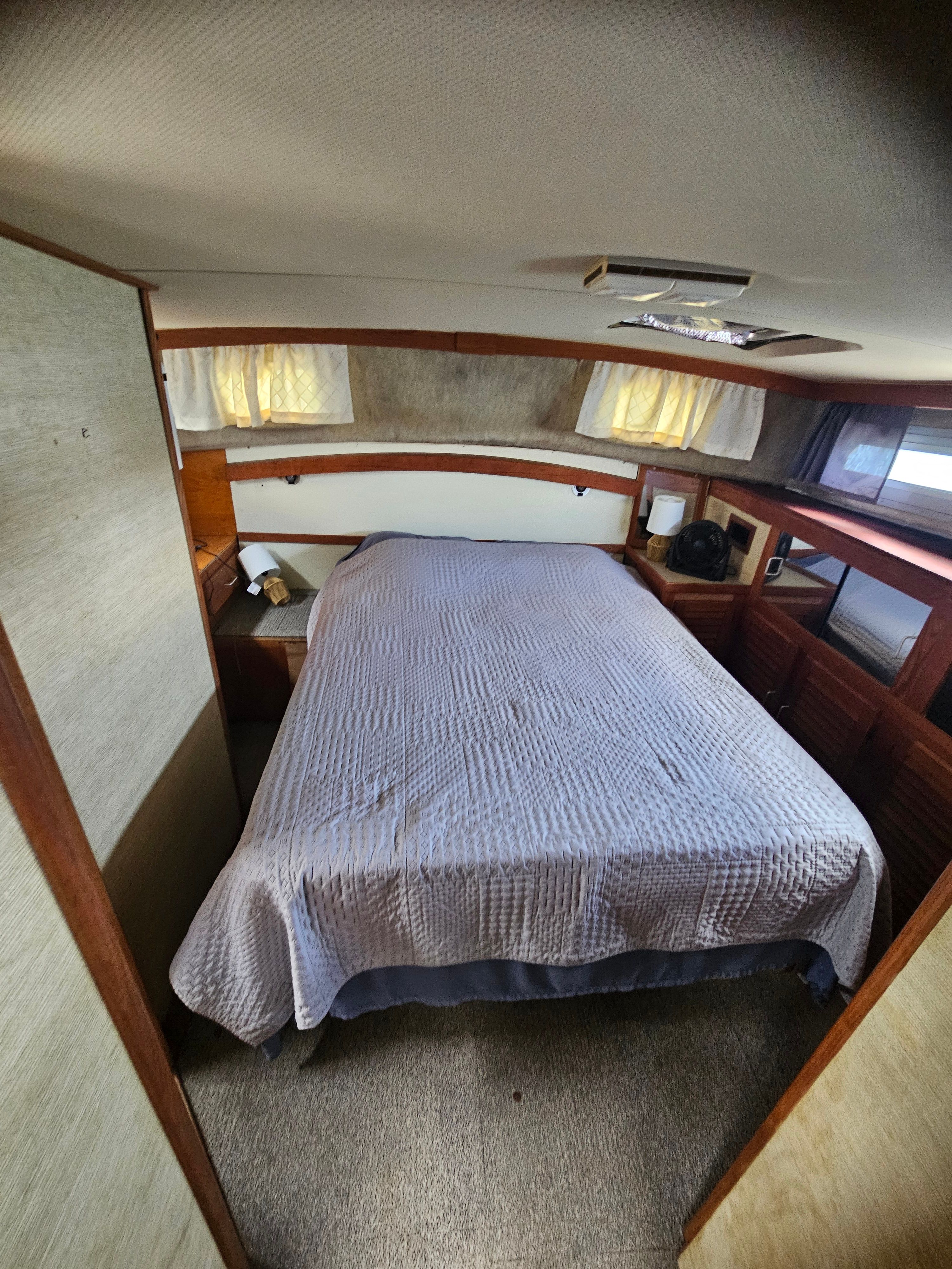 Interior of a 1984 Silverton 40 with a cozy bed and wooden furnishings.