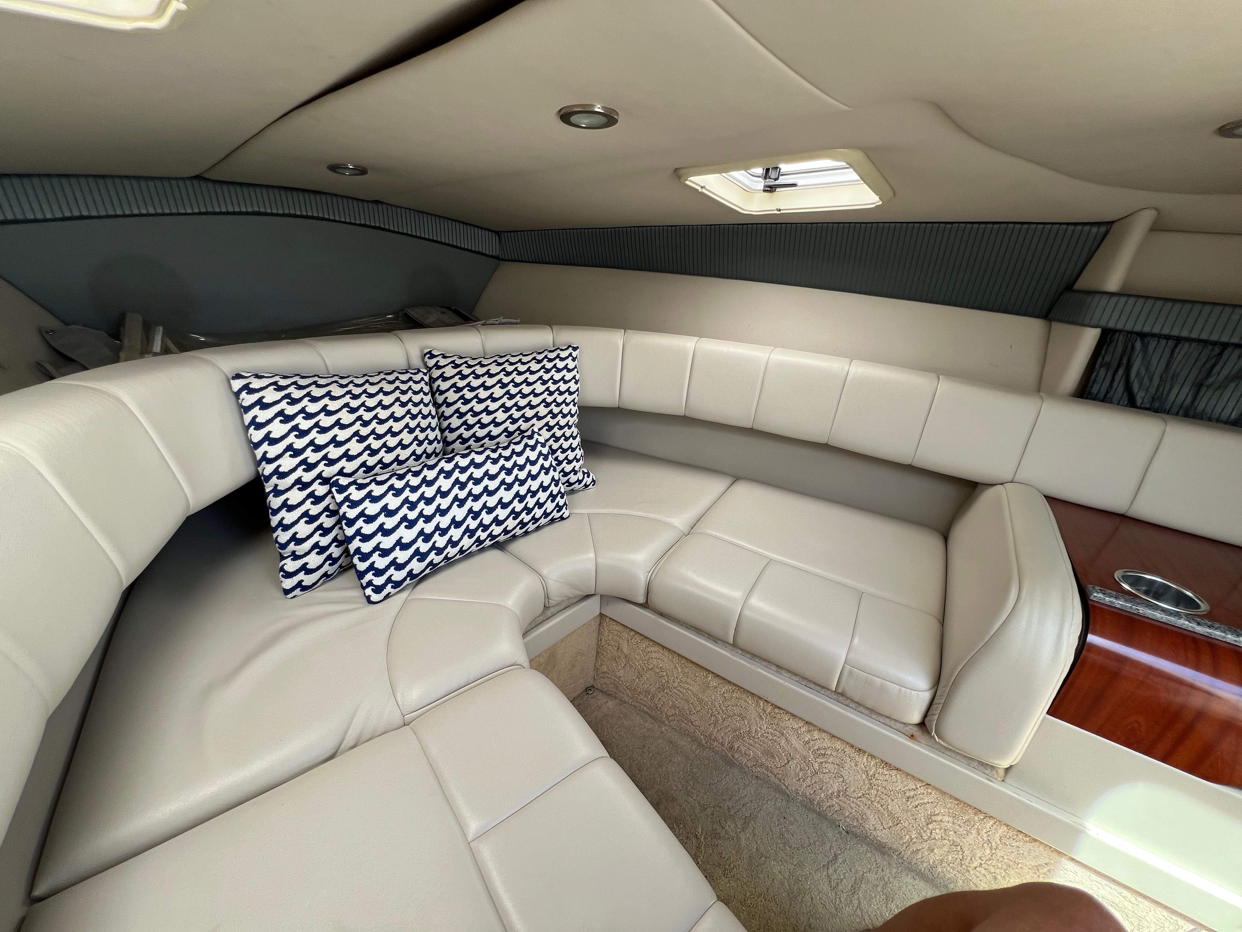 The image shows the interior of a 2005 Formula 260 Sun Sport with beige leather seating and decorative pillows.