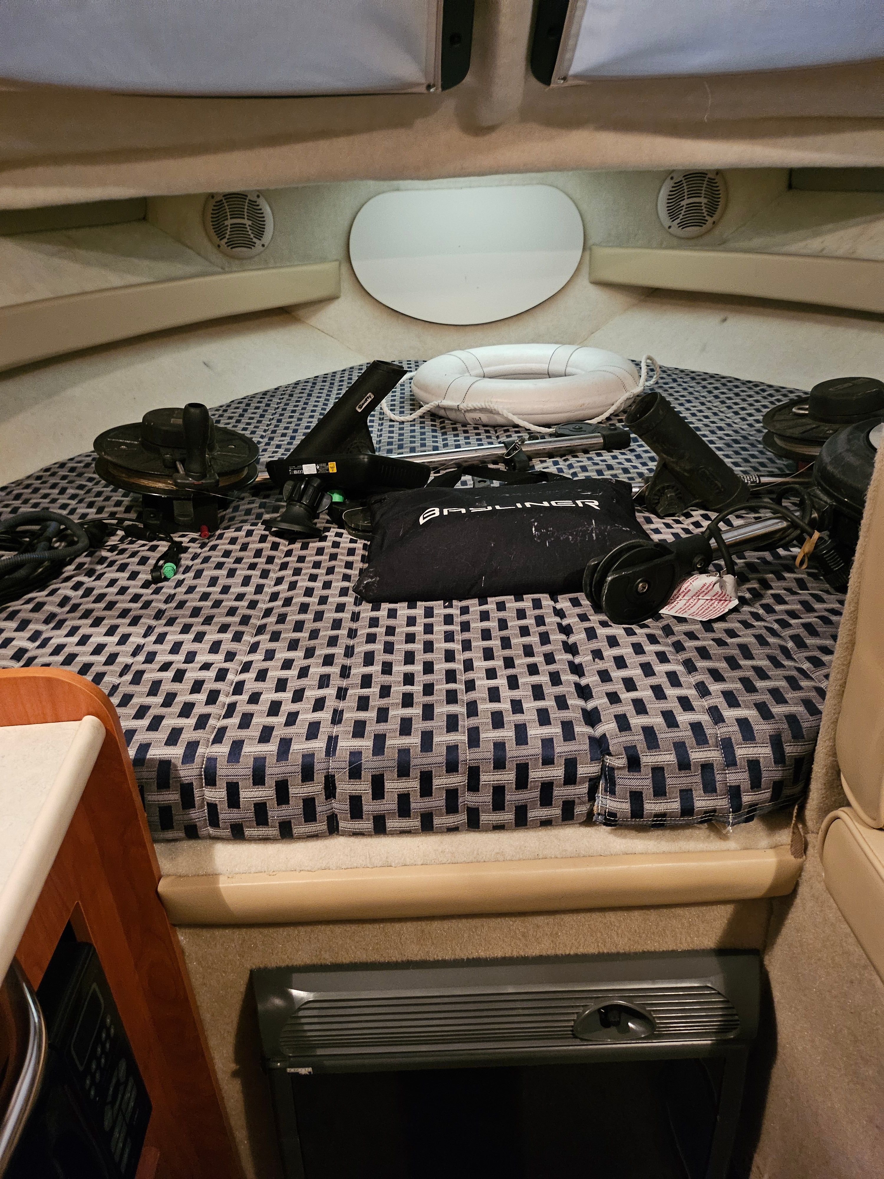 Interior of a 2005 Bayliner 242 Ceara with cushioned bed and equipment.