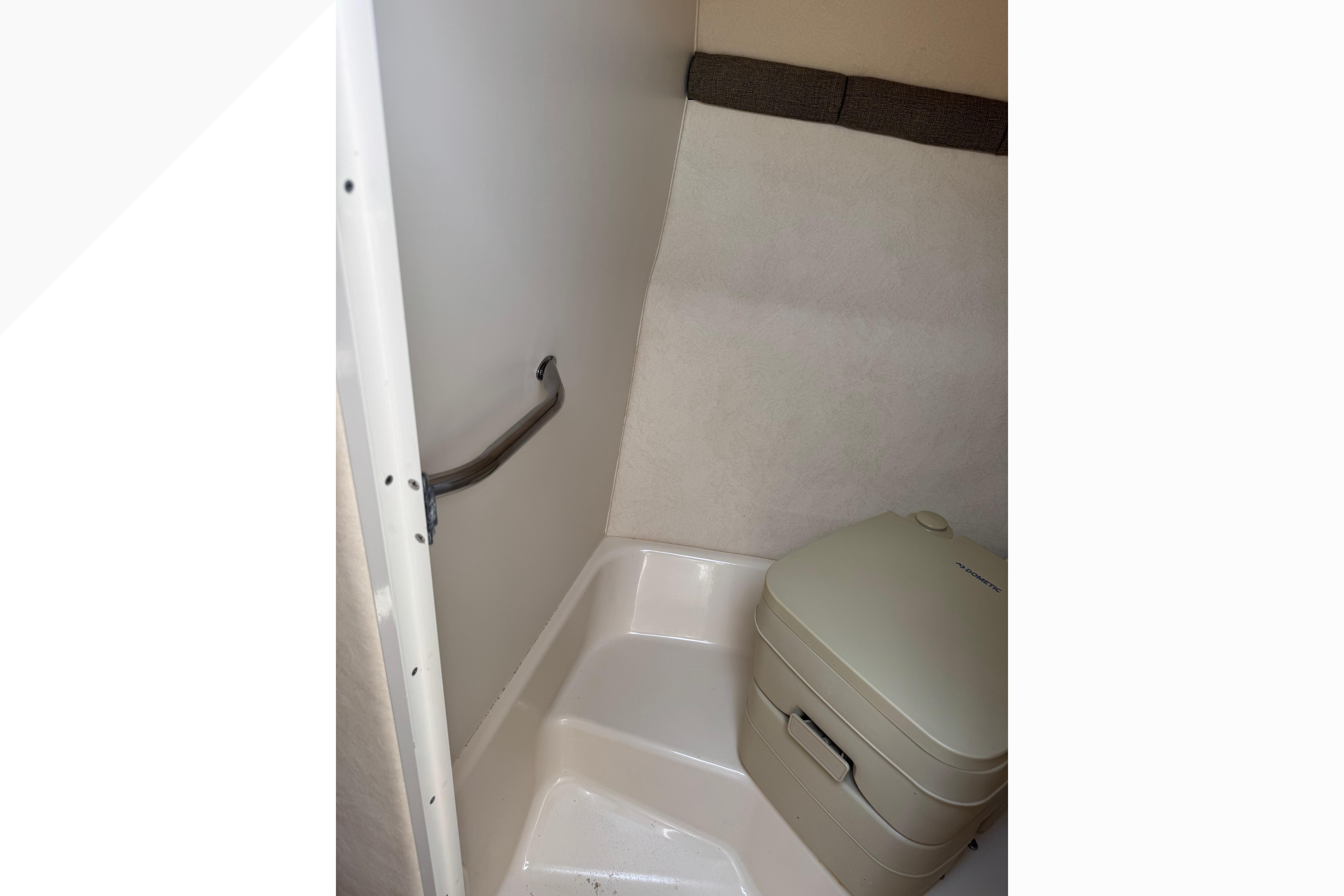 2001 Sea Ray 245 Weekender boat bathroom with portable toilet and handrail.