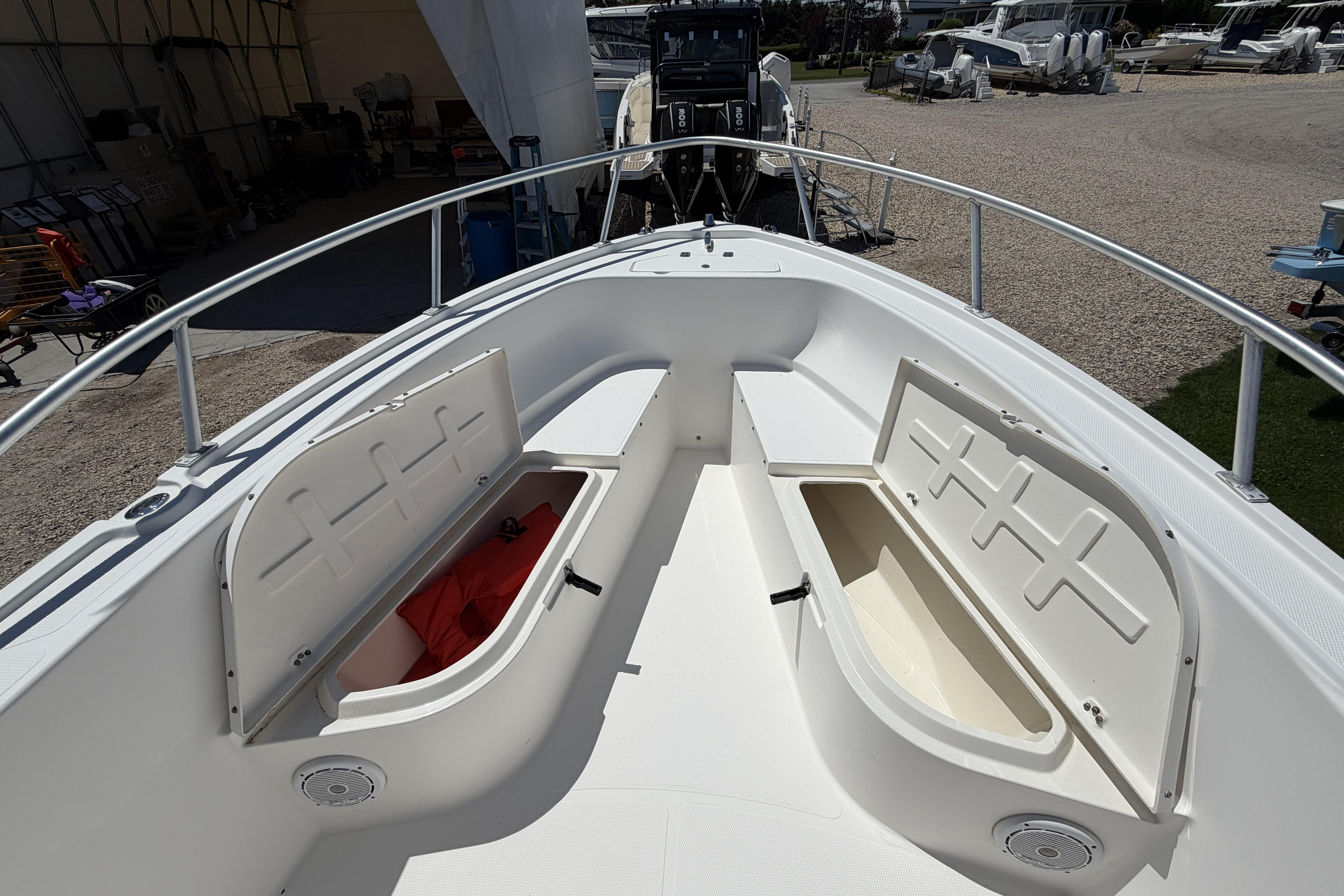 2006 Mako 212 Center Console boat with open storage compartments on deck.