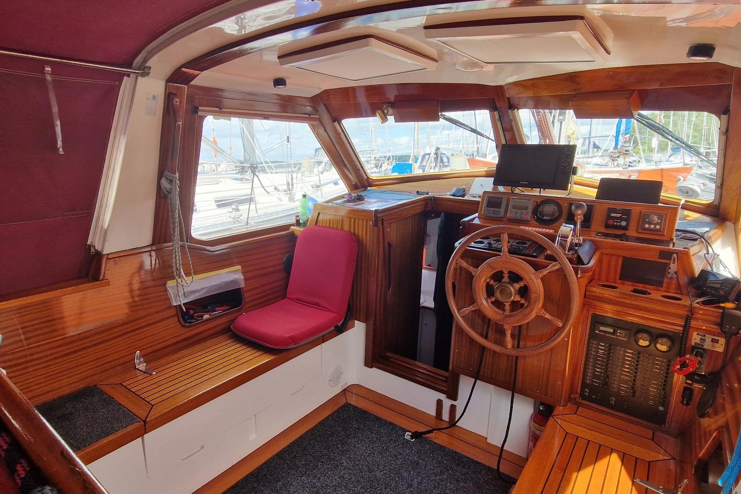 Interior of 2002 Vilm 116 yacht with wooden helm and seating area.