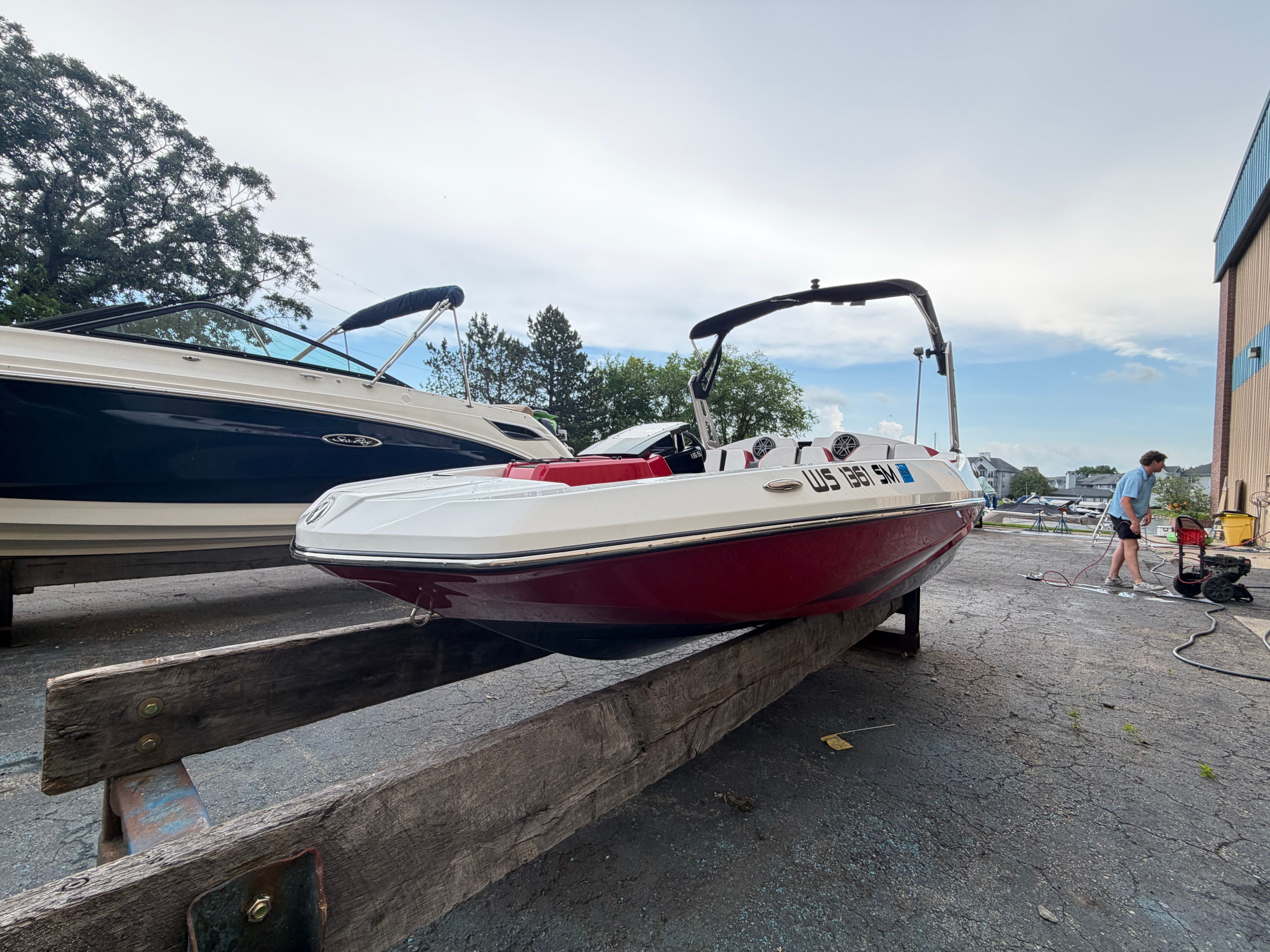 A 2021 Scarab 165 ID boat is on a wooden stand on land.