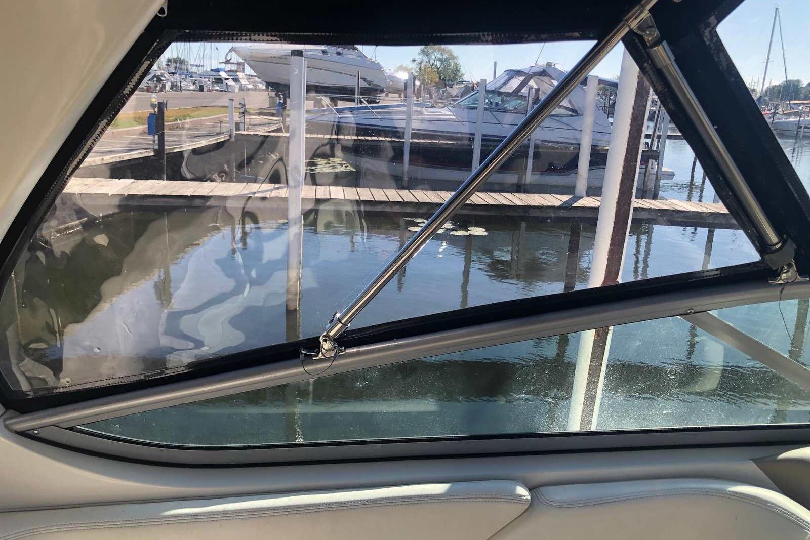 View from inside a 2005 Sea Ray 280 Sundancer, overlooking marina and docked boats.
