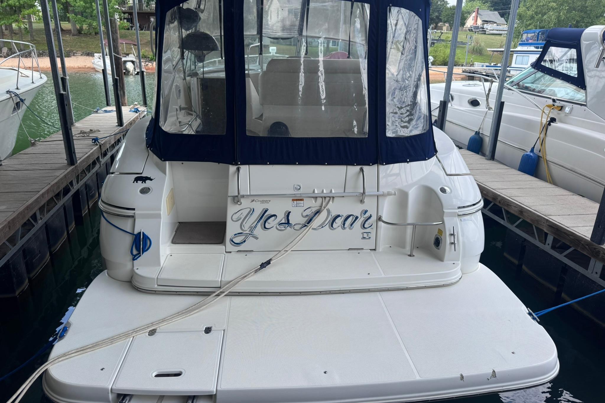 2002 Cruisers Yachts 3275 Express docked, rear view with blue canopy.