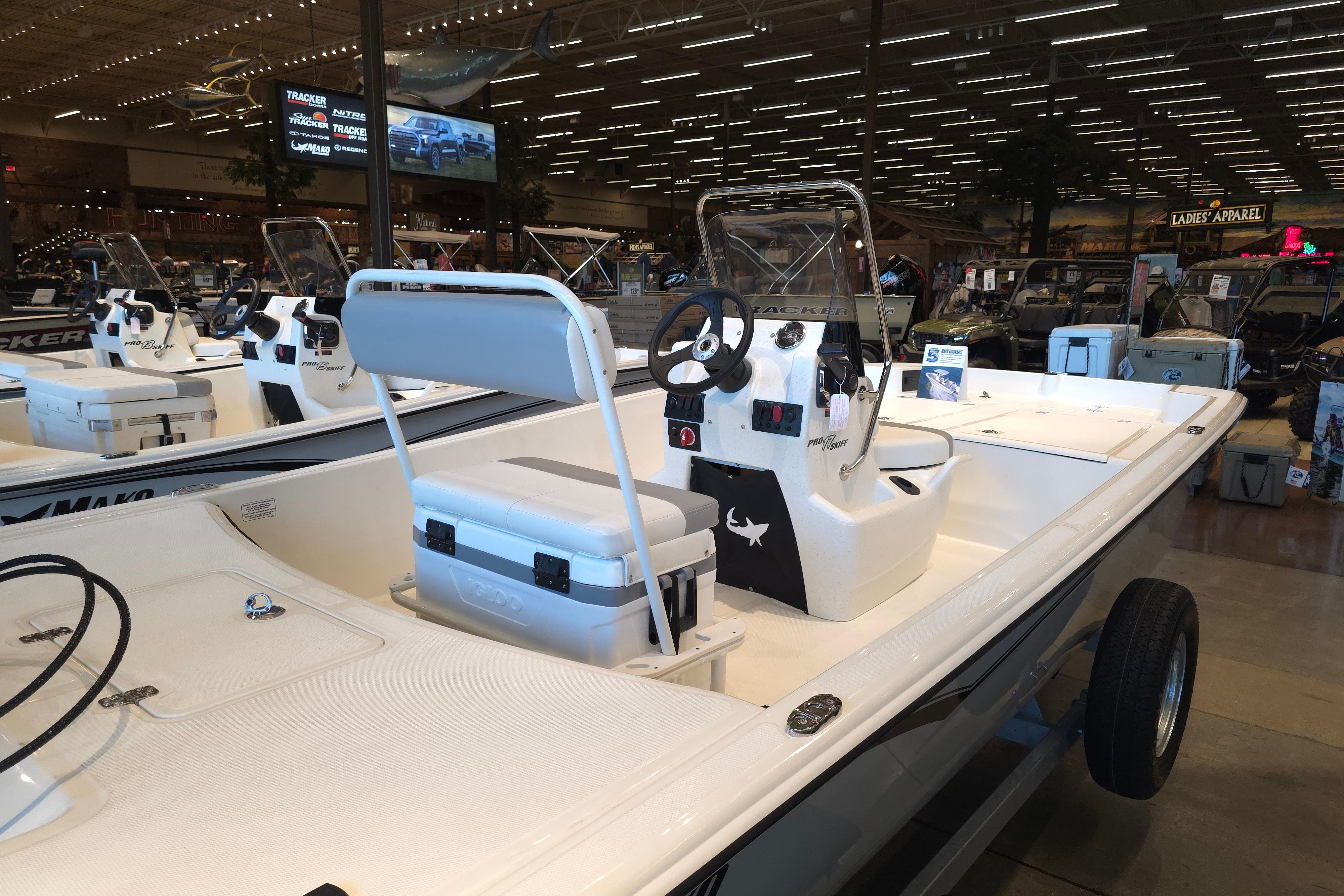 2026 Mako Pro Skiff 17 CC boat displayed in a showroom with modern interior features.