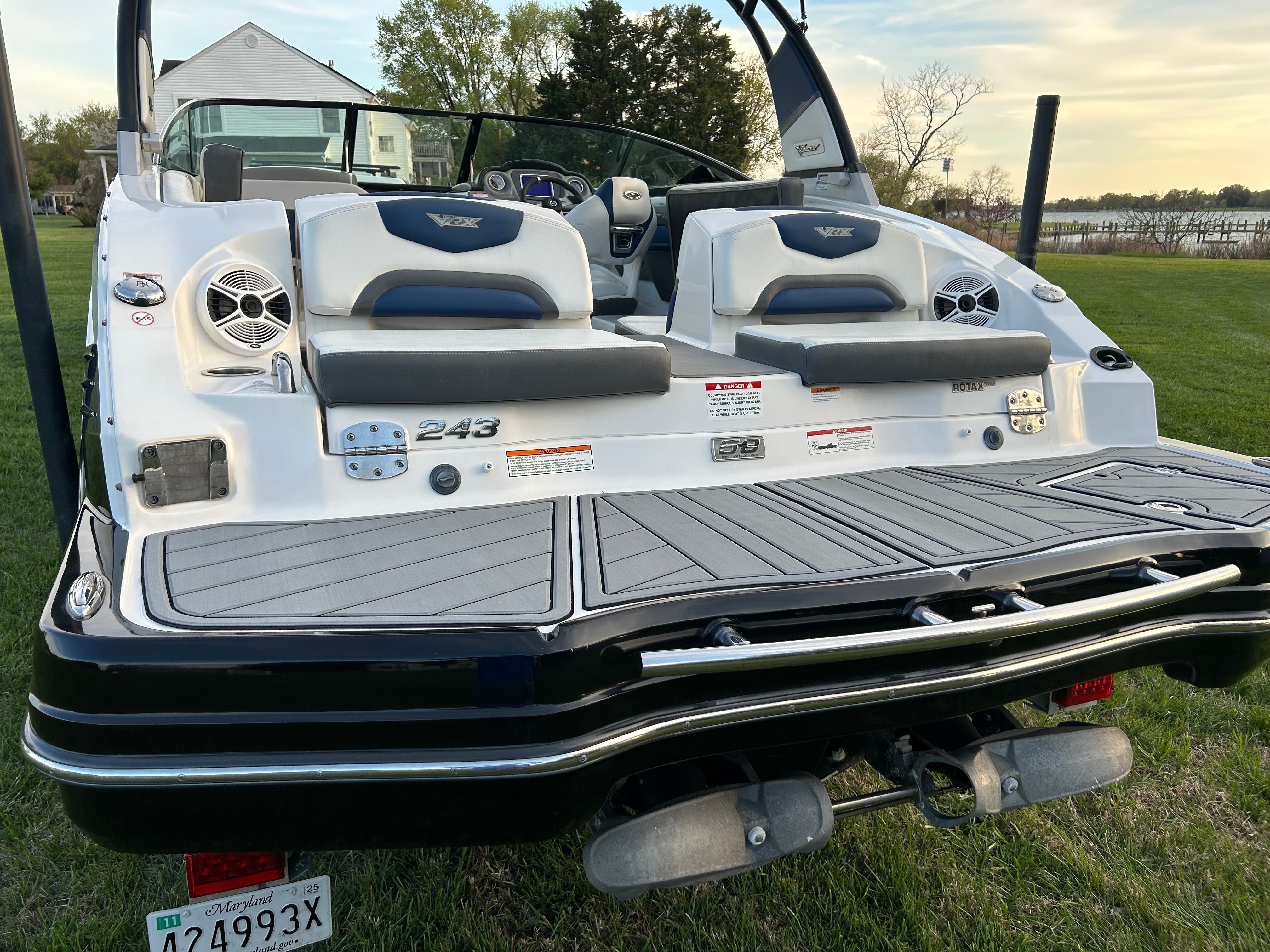 Rear view of a 2015 Chaparral Vortex 243 VRX boat on grass.