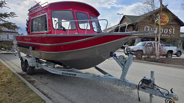 2024 Spartan 220 Maximus boat on trailer, parked in urban setting.