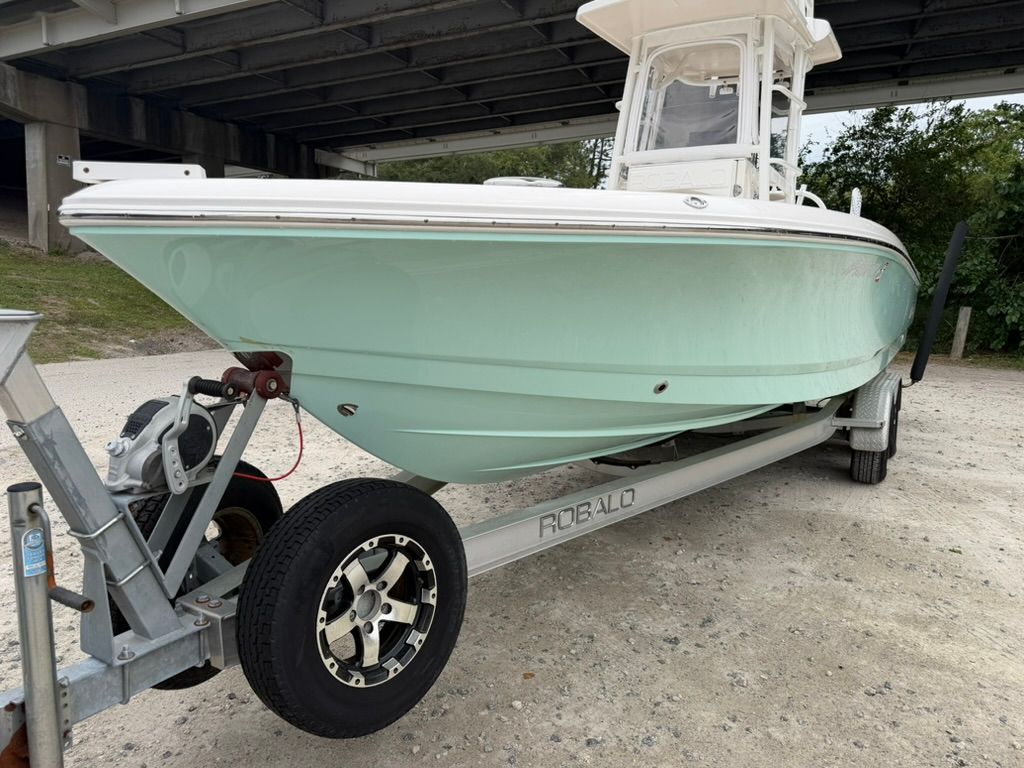 2018 Robalo 246 Cayman SD boat on trailer under bridge.